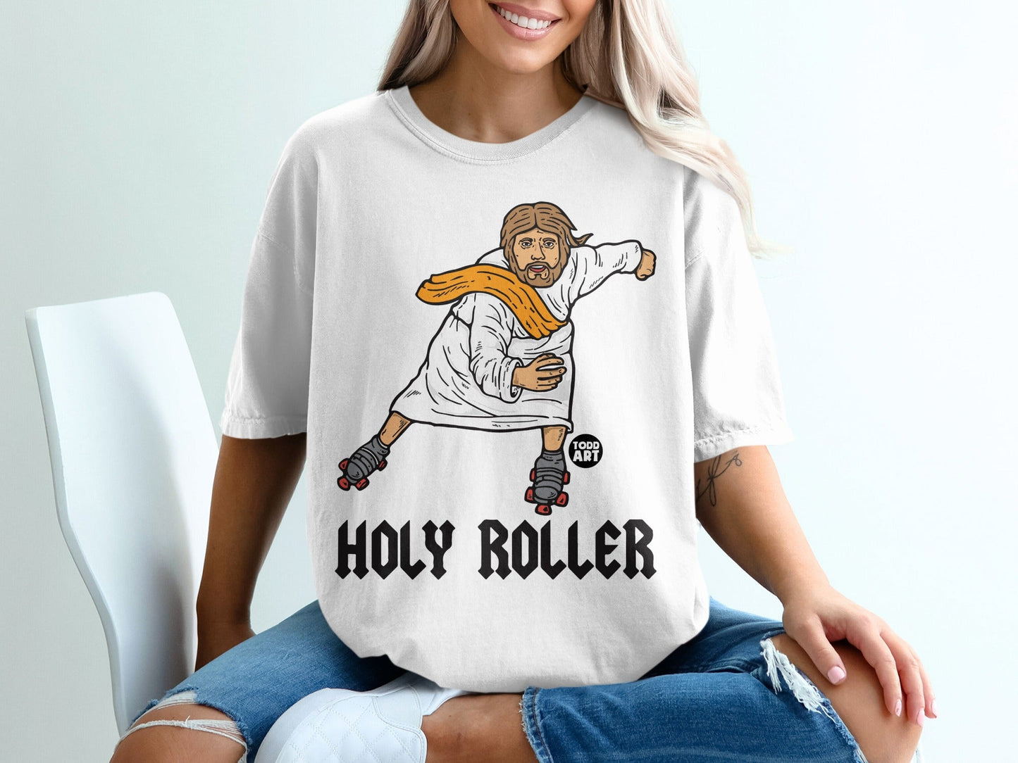 T-shirt with graphic of Jesus on roller skates, "Holy Roller" text.