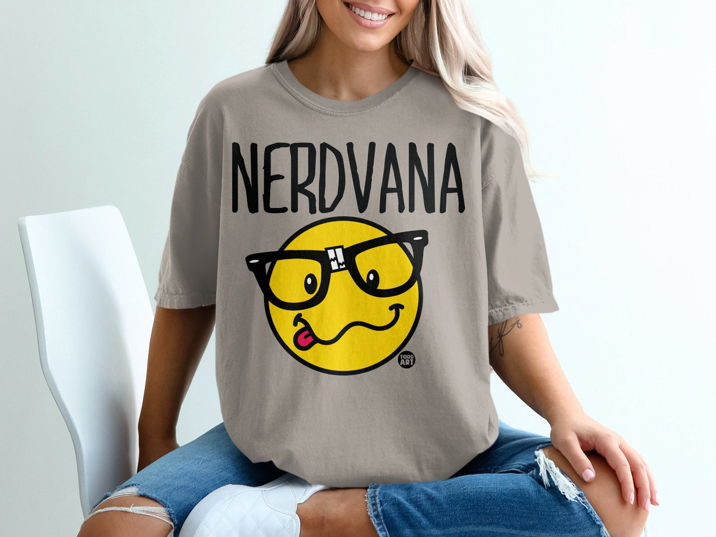 NERDVANA t-shirt with a smiling cartoon face wearing glasses and sticking out its tongue.