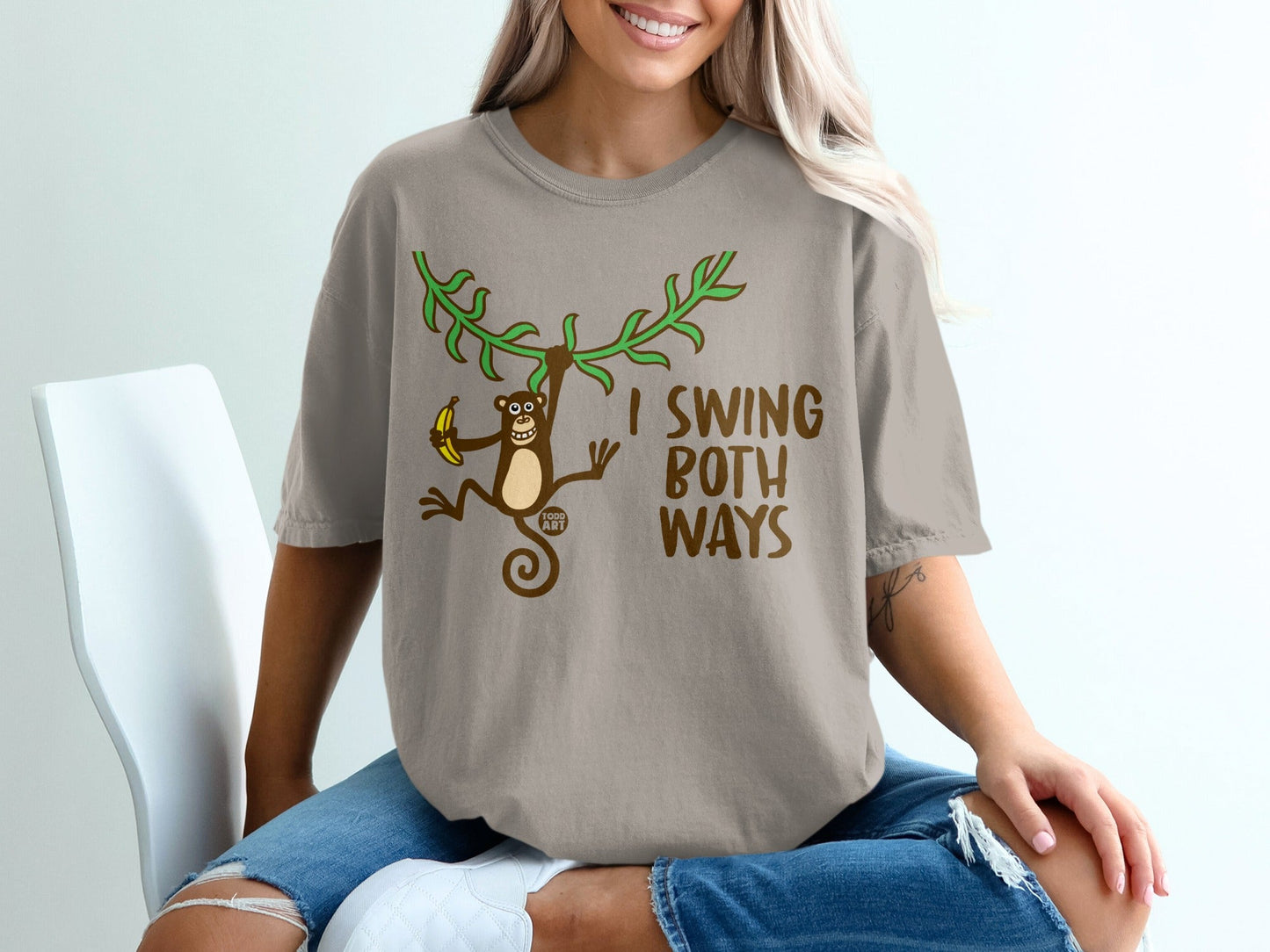 T-shirt with monkey swinging from branches, holding a banana, with text "I SWING BOTH WAYS".
