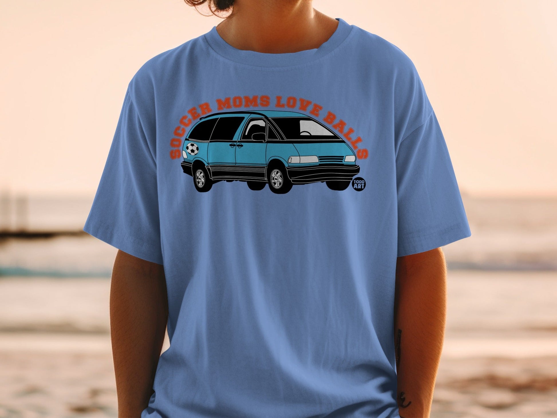 Blue minivan with a soccer ball on a t-shirt with "SOCCER MOMS LOVE BALLS" text.