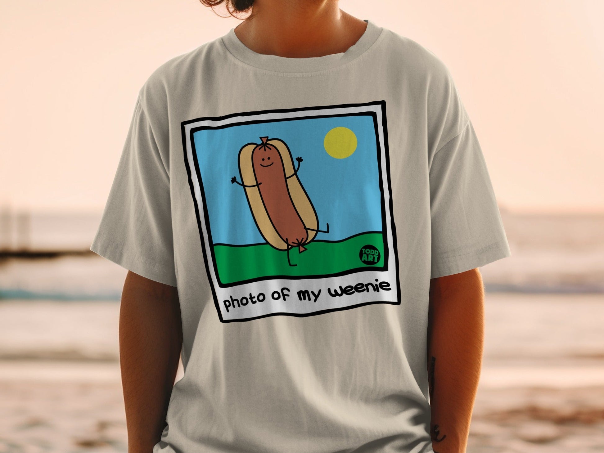Cartoon hot dog with arms and legs, smiling, with sun and grass.