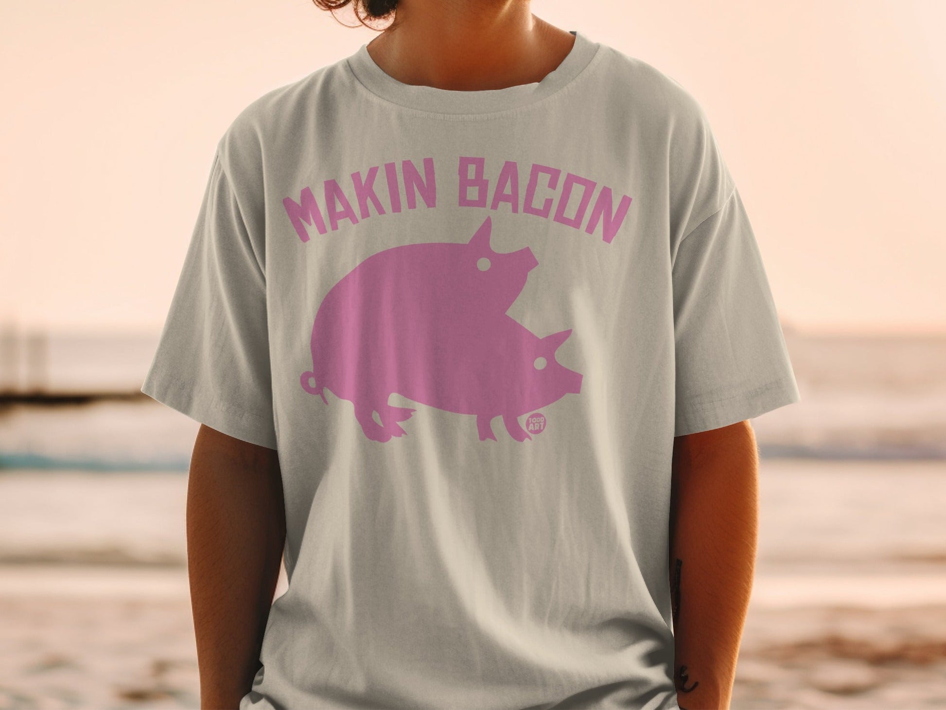 T-shirt with pink graphic of two pigs and text "MAKIN BACON".