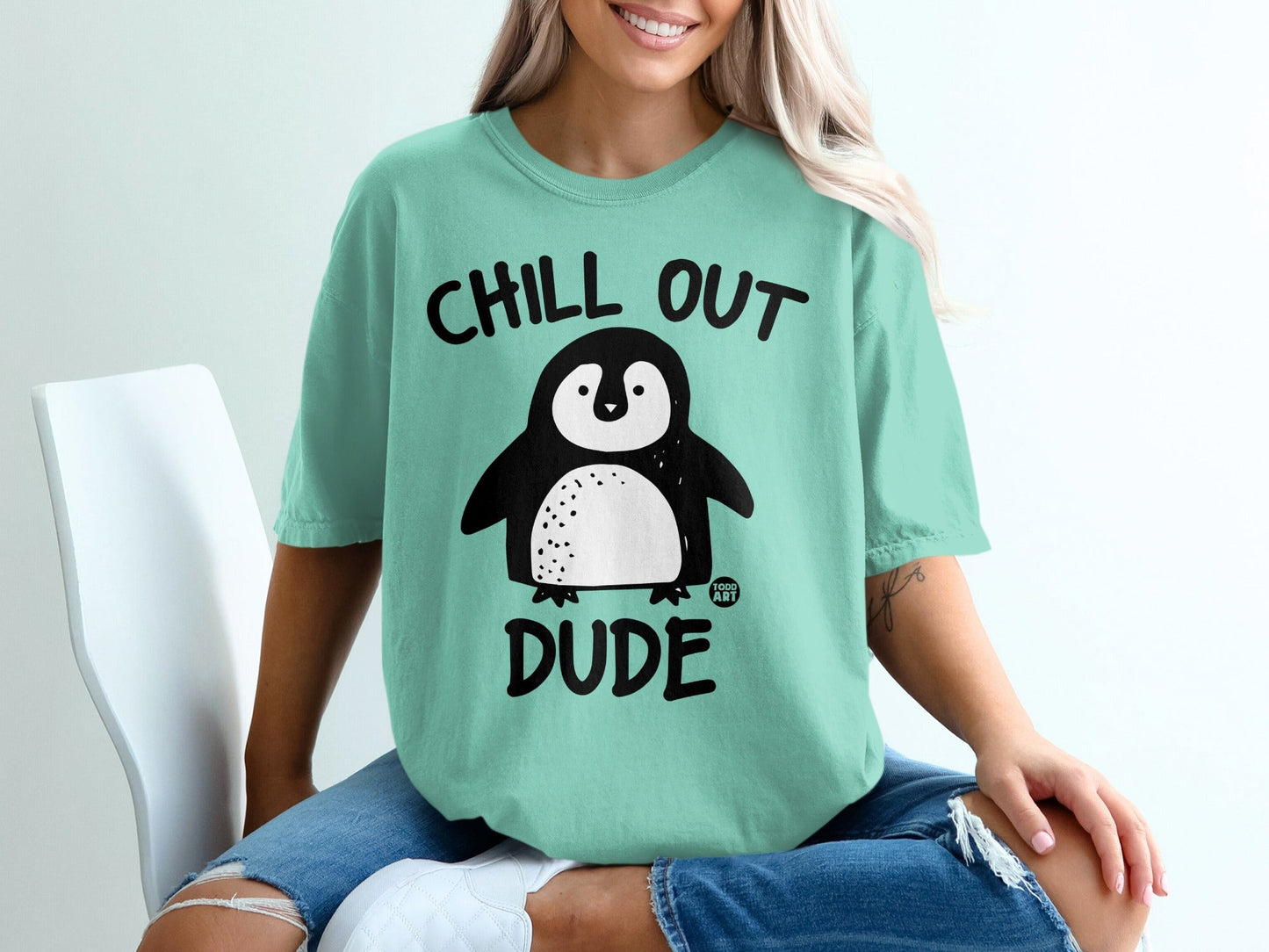 Teal t-shirt with a cartoon penguin saying "Chill Out Dude".