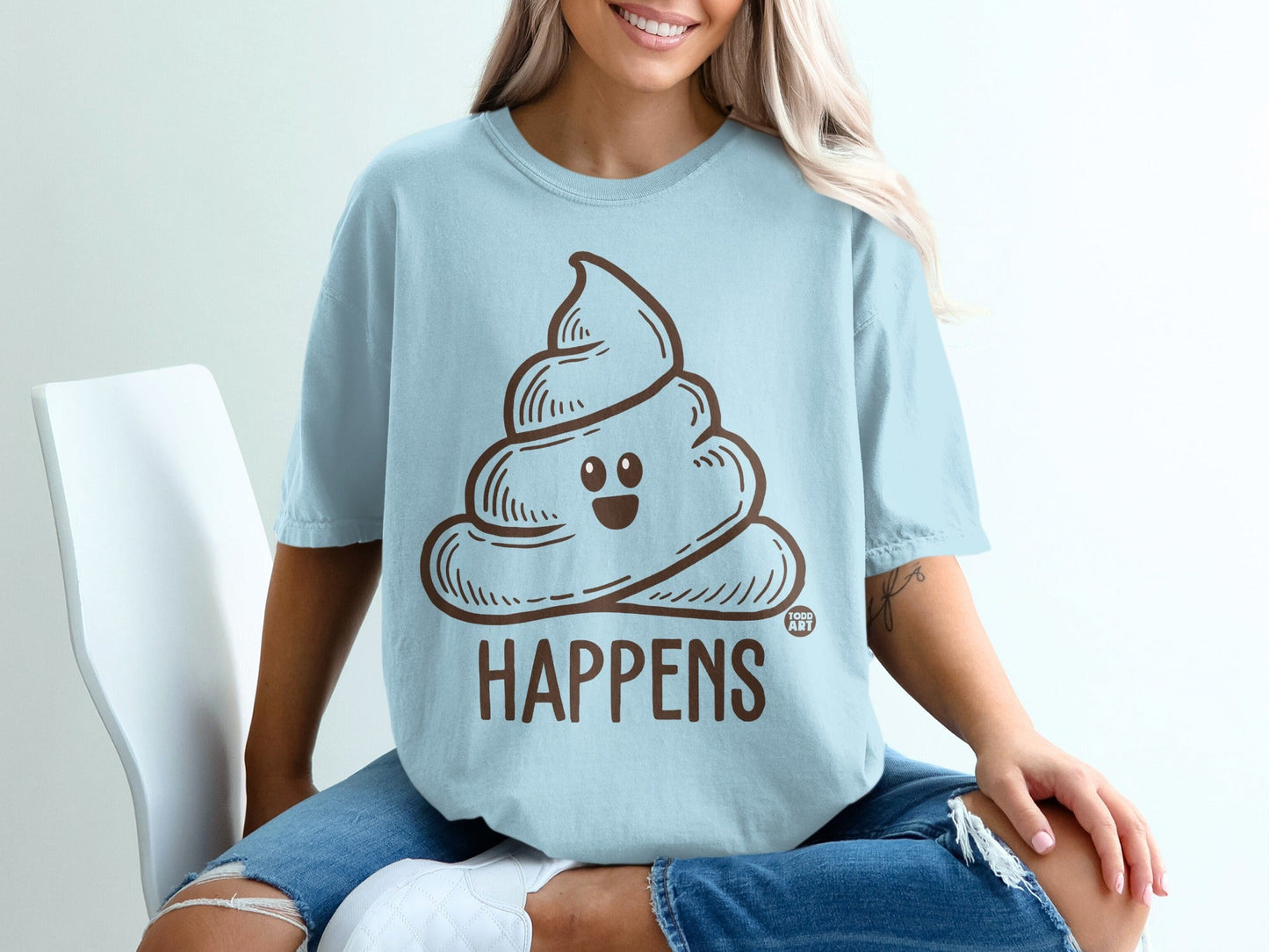 Light blue t-shirt with a smiling poop emoji and the word "HAPPENS".