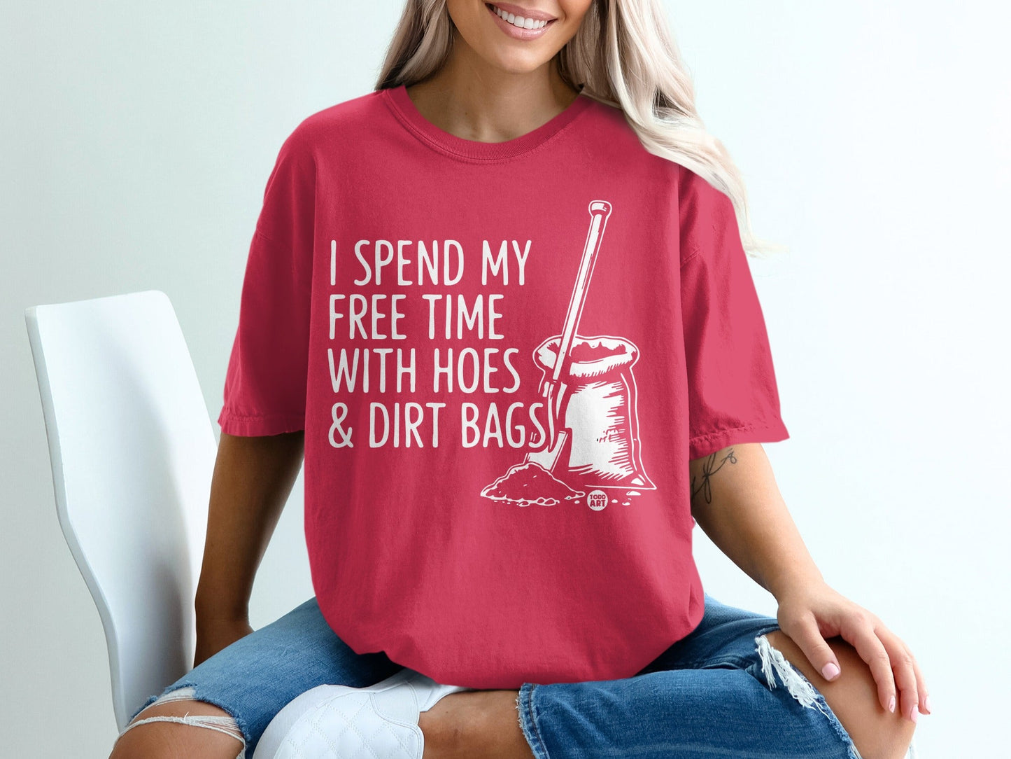 Red t-shirt with white text and illustration reading "I spend my free time with hoes & dirt bags."