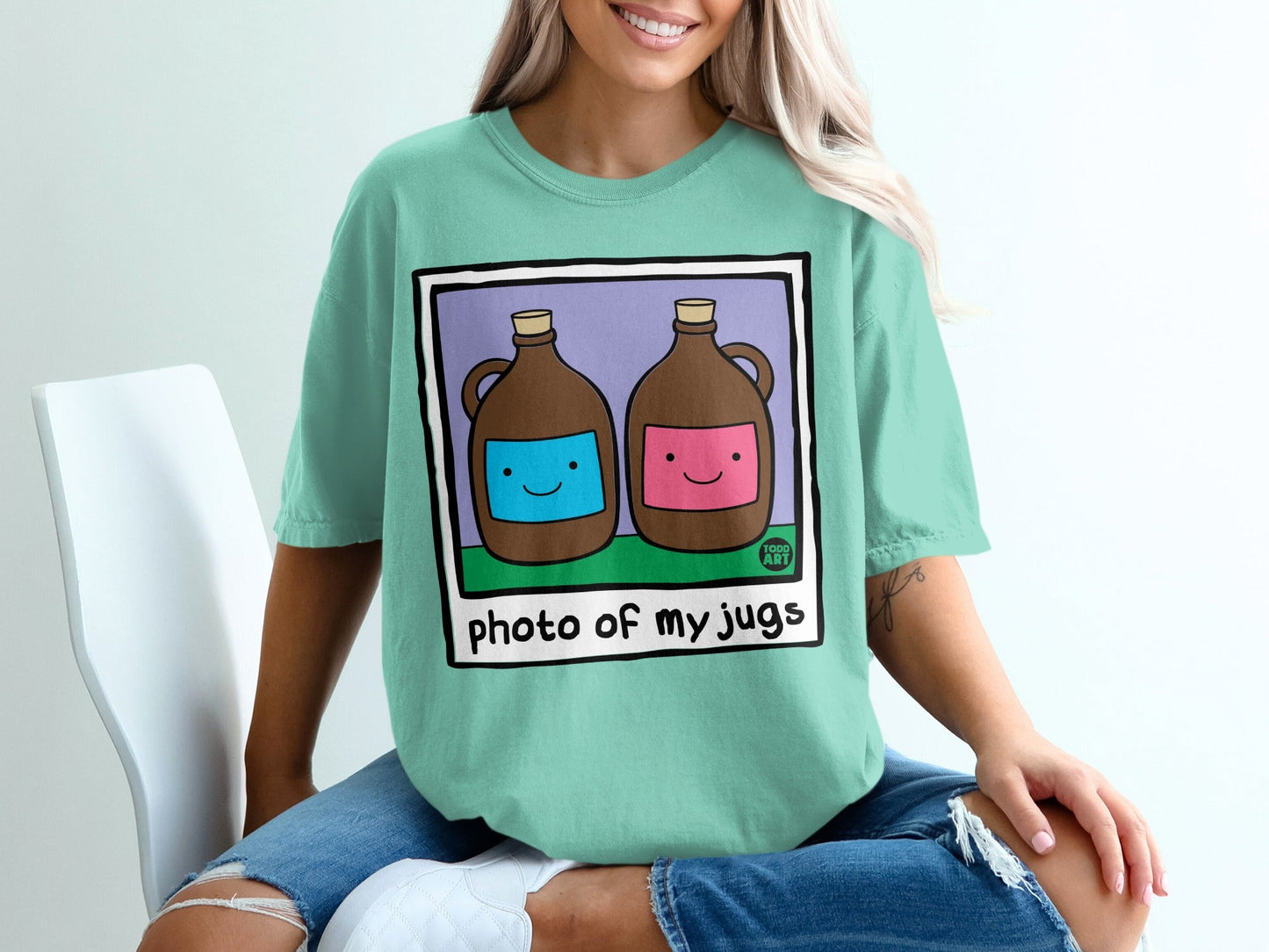 Two cartoon jugs with smiling faces on a teal t-shirt.