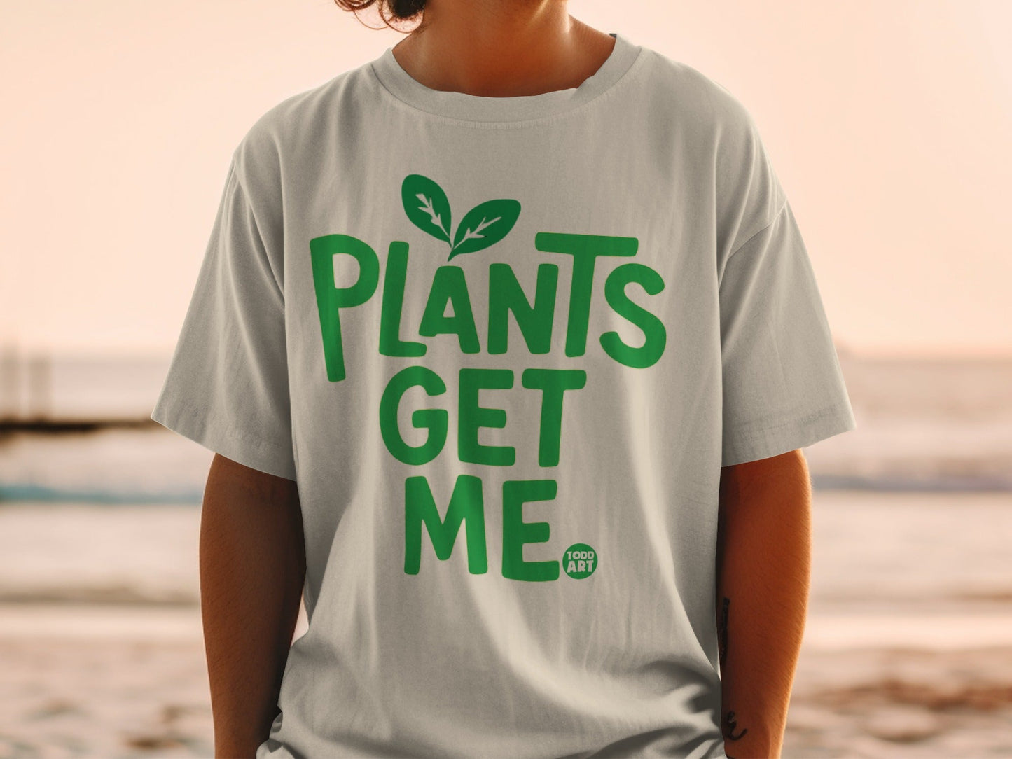 Green t-shirt with "PLANTS GET ME" text and a small leaf logo.