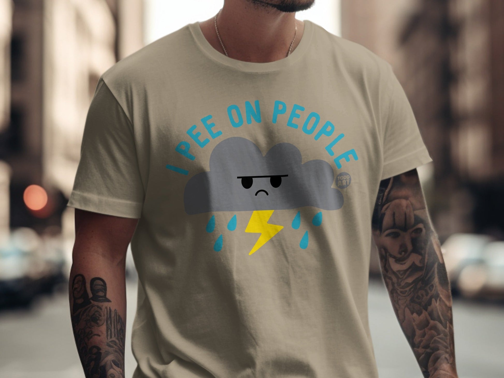 Tan t-shirt with a grumpy cloud, rain, and lightning bolt graphic.