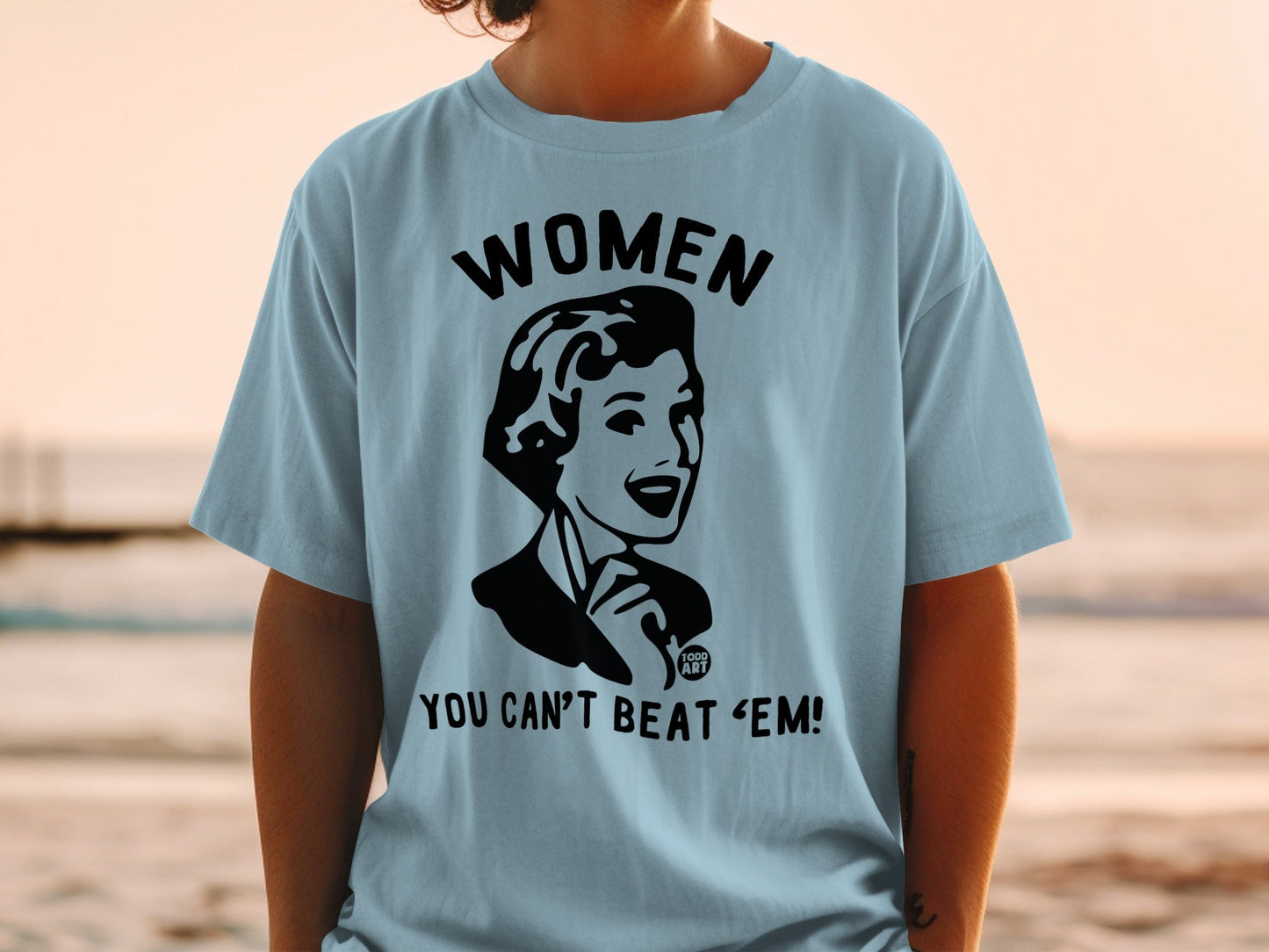 Light blue t-shirt with black graphic: "WOMEN YOU CAN'T BEAT 'EM!"