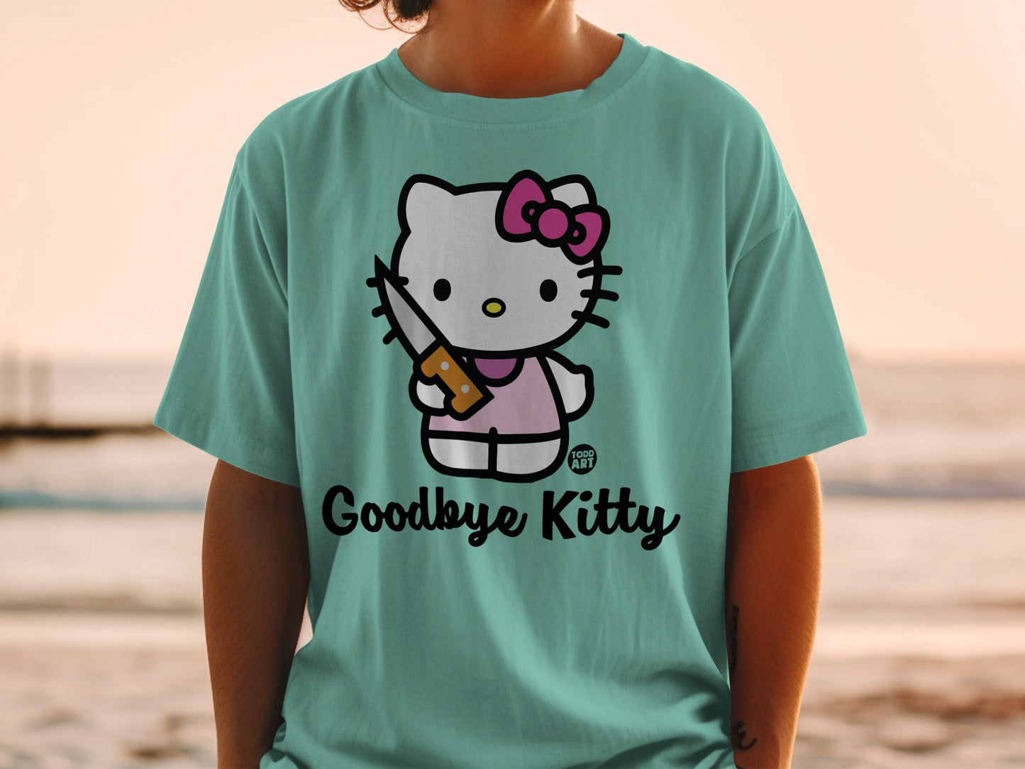 Teal t-shirt with Hello Kitty holding a knife, "Goodbye Kitty" text.