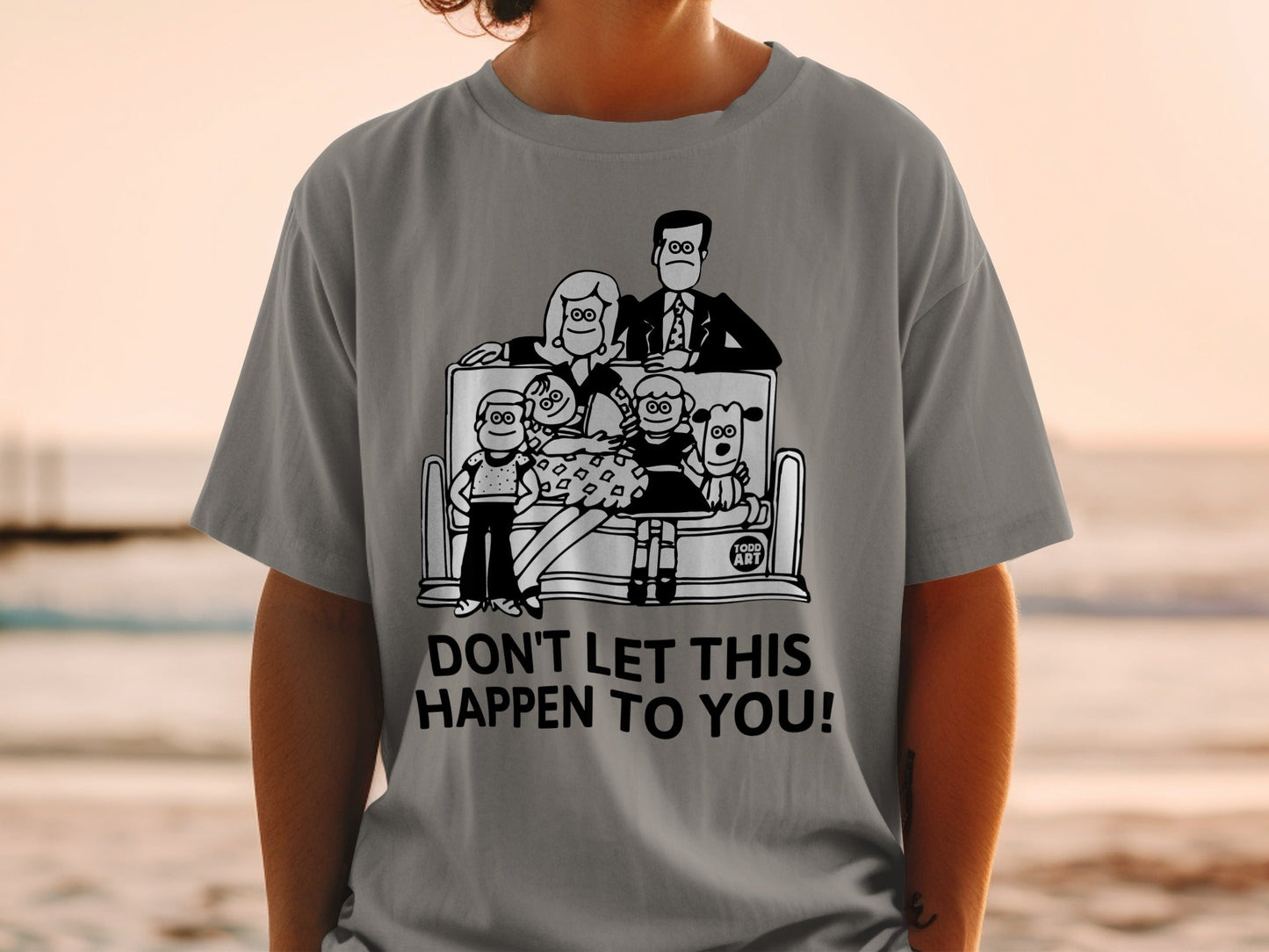 T-shirt with cartoon family and dogs, text "DON'T LET THIS HAPPEN TO YOU!".