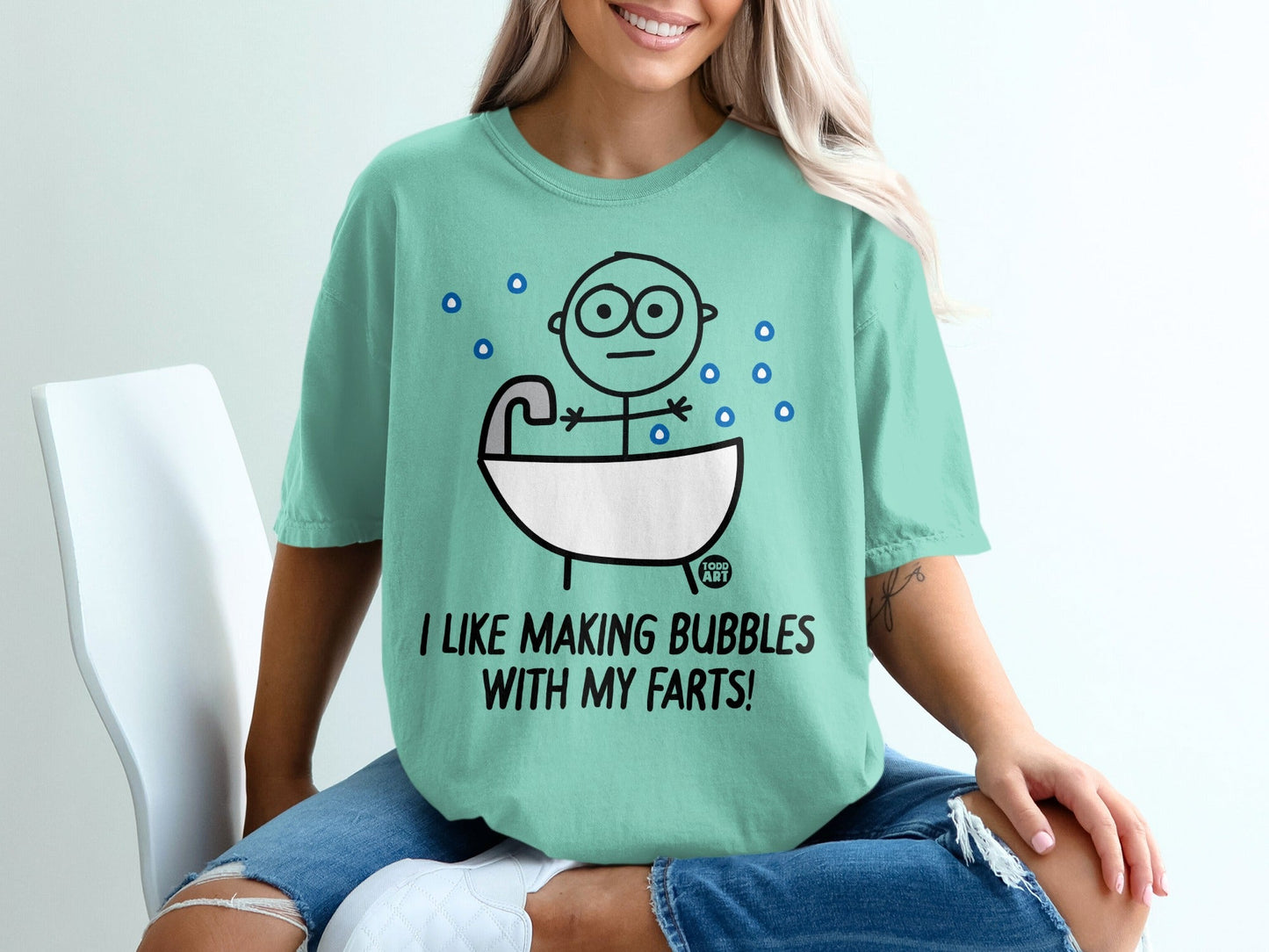 Mint t-shirt with cartoon person in bathtub and text "I LIKE MAKING BUBBLES WITH MY FARTS!".