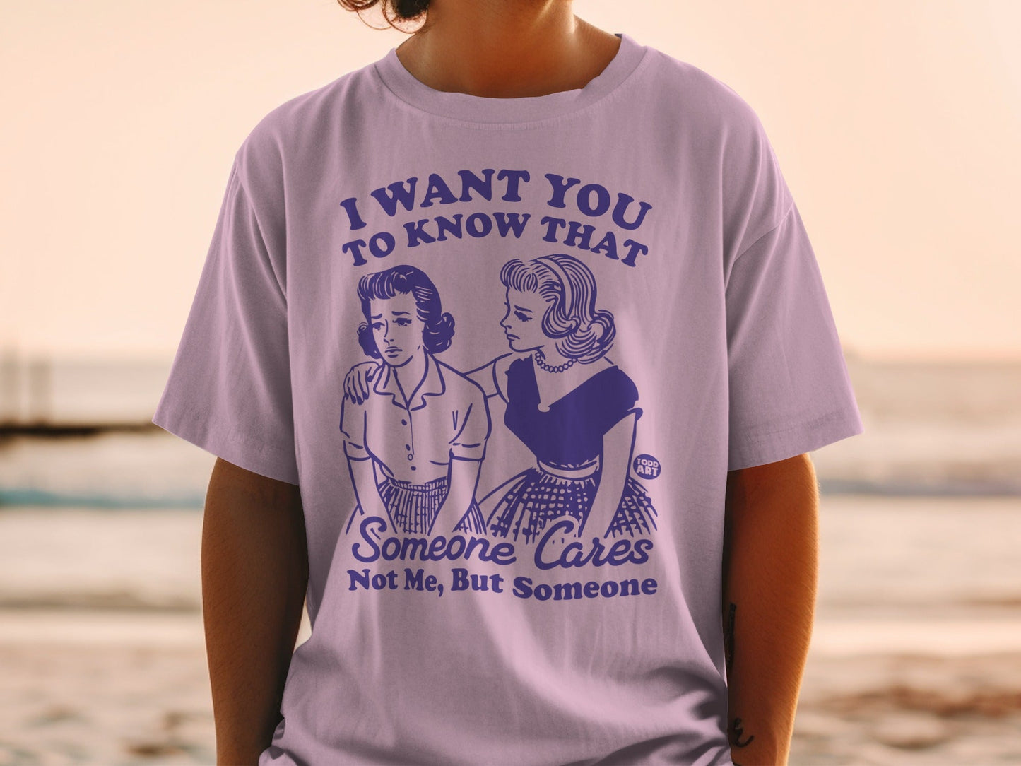 Lilac t-shirt with distressed "I want you to know that someone cares, not me, but someone" graphic.