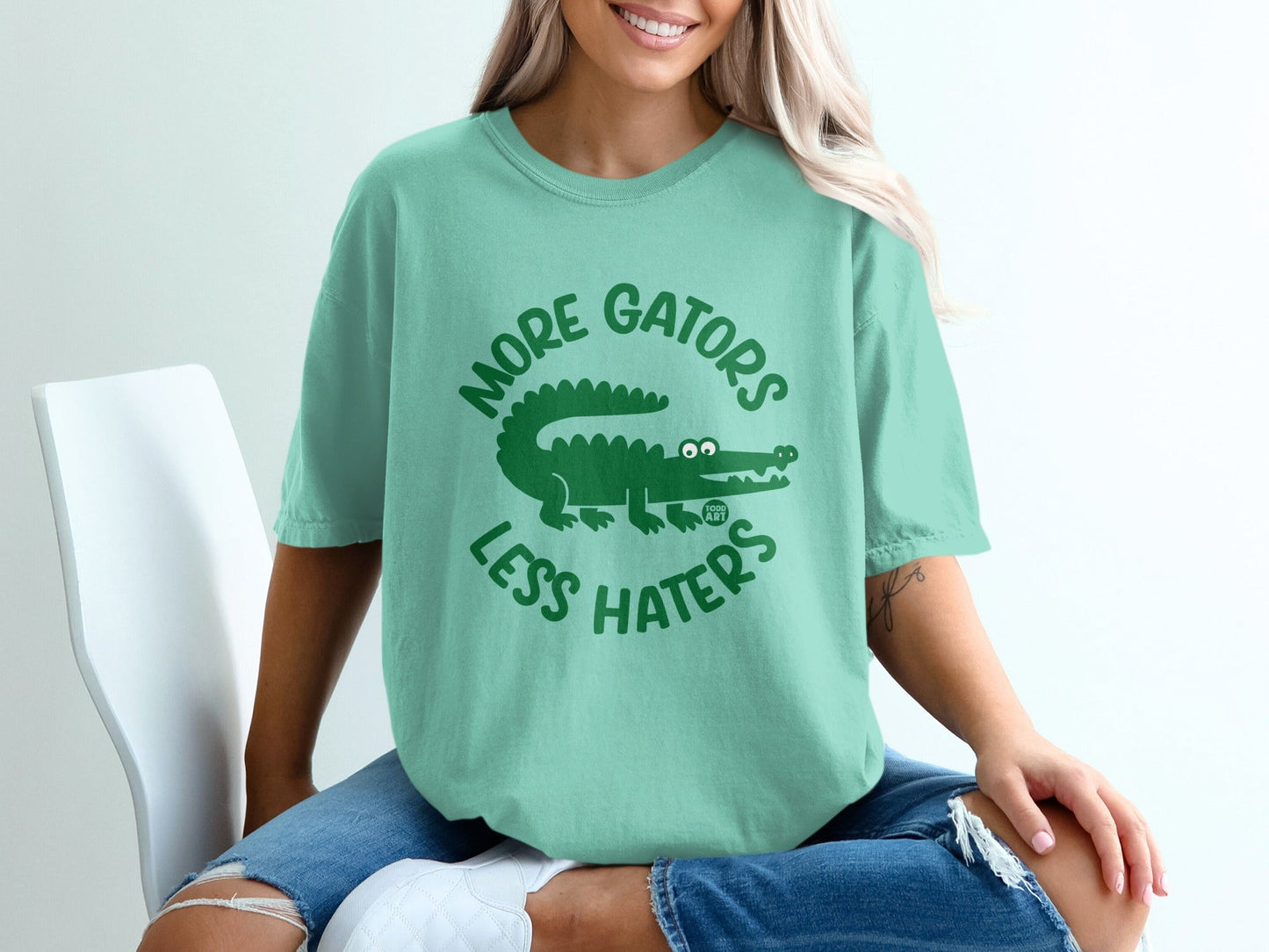 Mint green t-shirt with green alligator graphic and text "More Gators Less Haters."