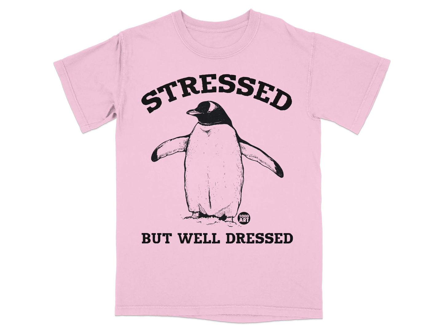 Pink t-shirt with a drawing of a penguin and text reading "STRESSED BUT WELL DRESSED".