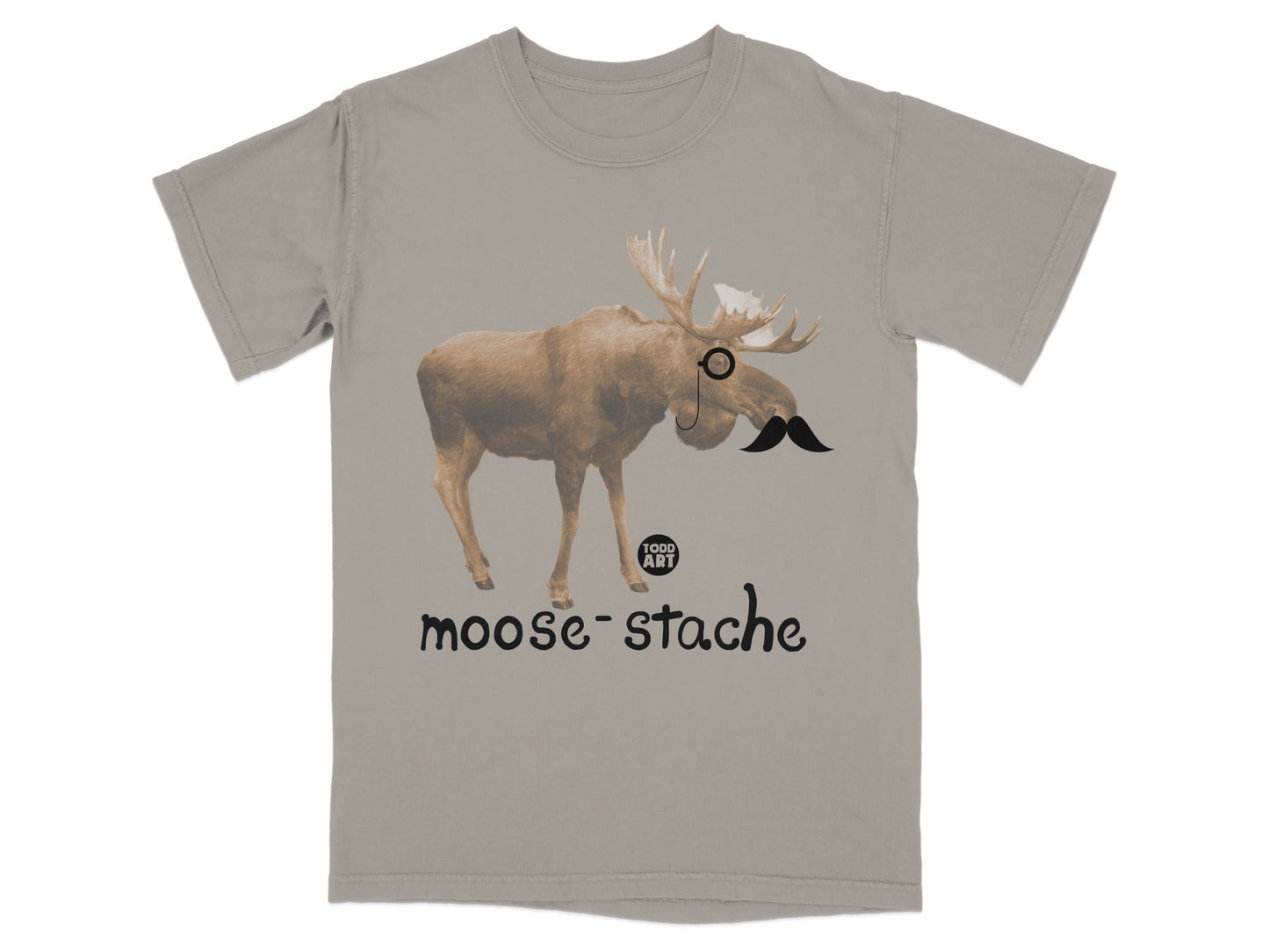 Tan t-shirt with a moose wearing a monocle and mustache, text "moose-stache".