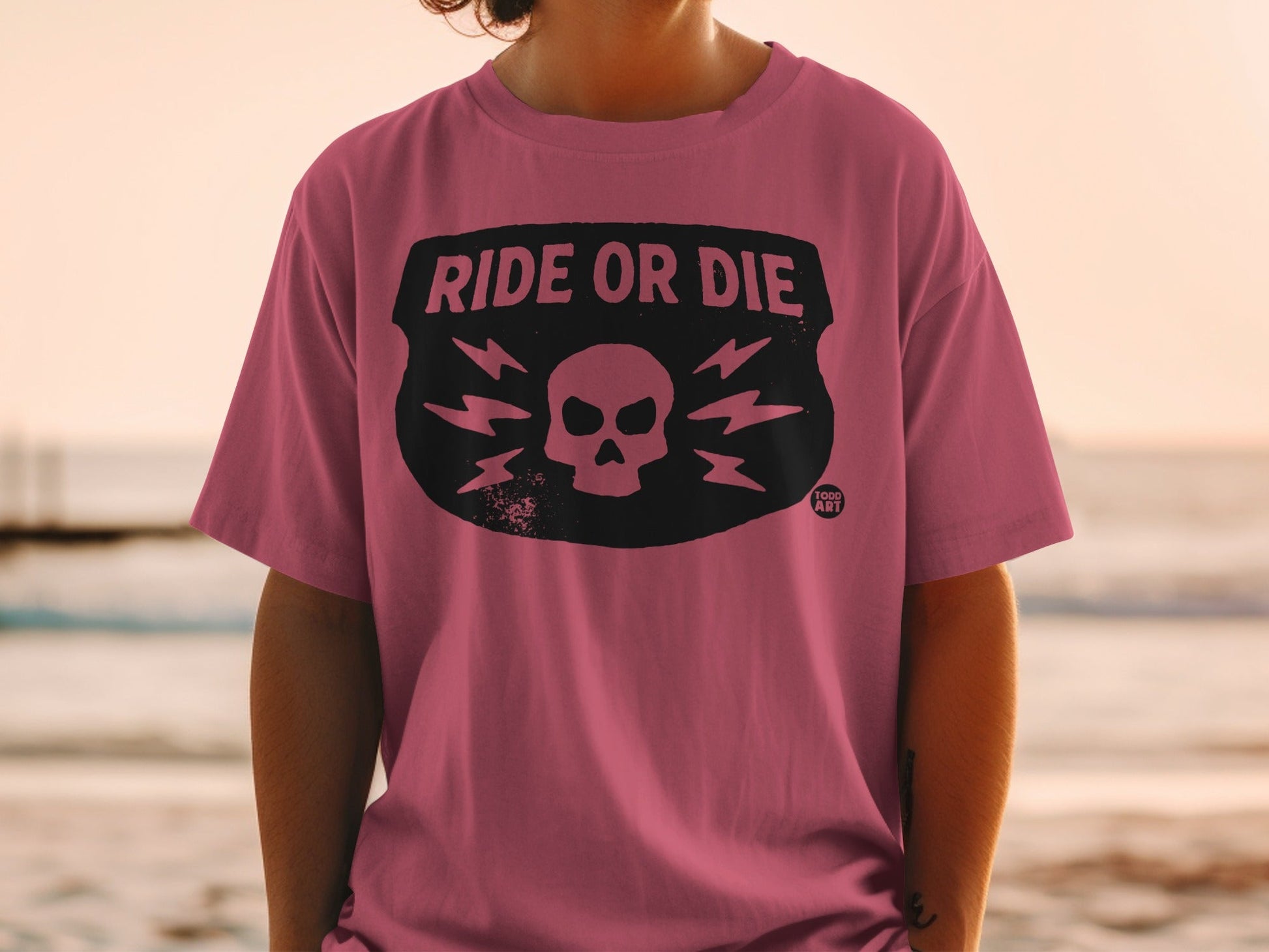 Pink t-shirt with black "Ride or Die" skull and lightning bolt design.