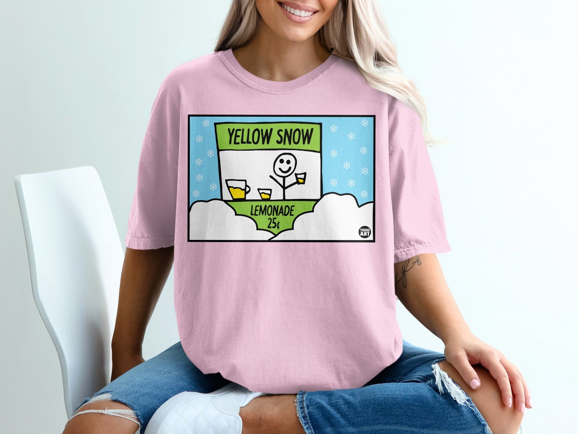 Pink t-shirt with "Yellow Snow Lemonade" sign and cartoon character.