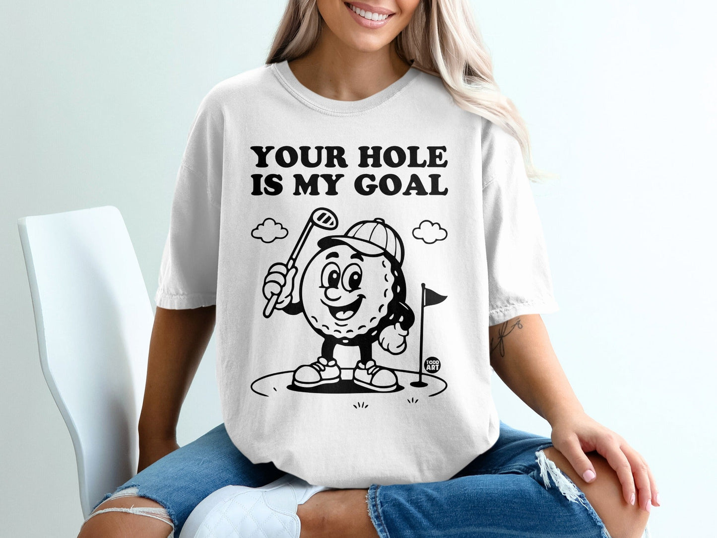 Graphic tee with "Your Hole Is My Goal" text and cartoon golf ball character.