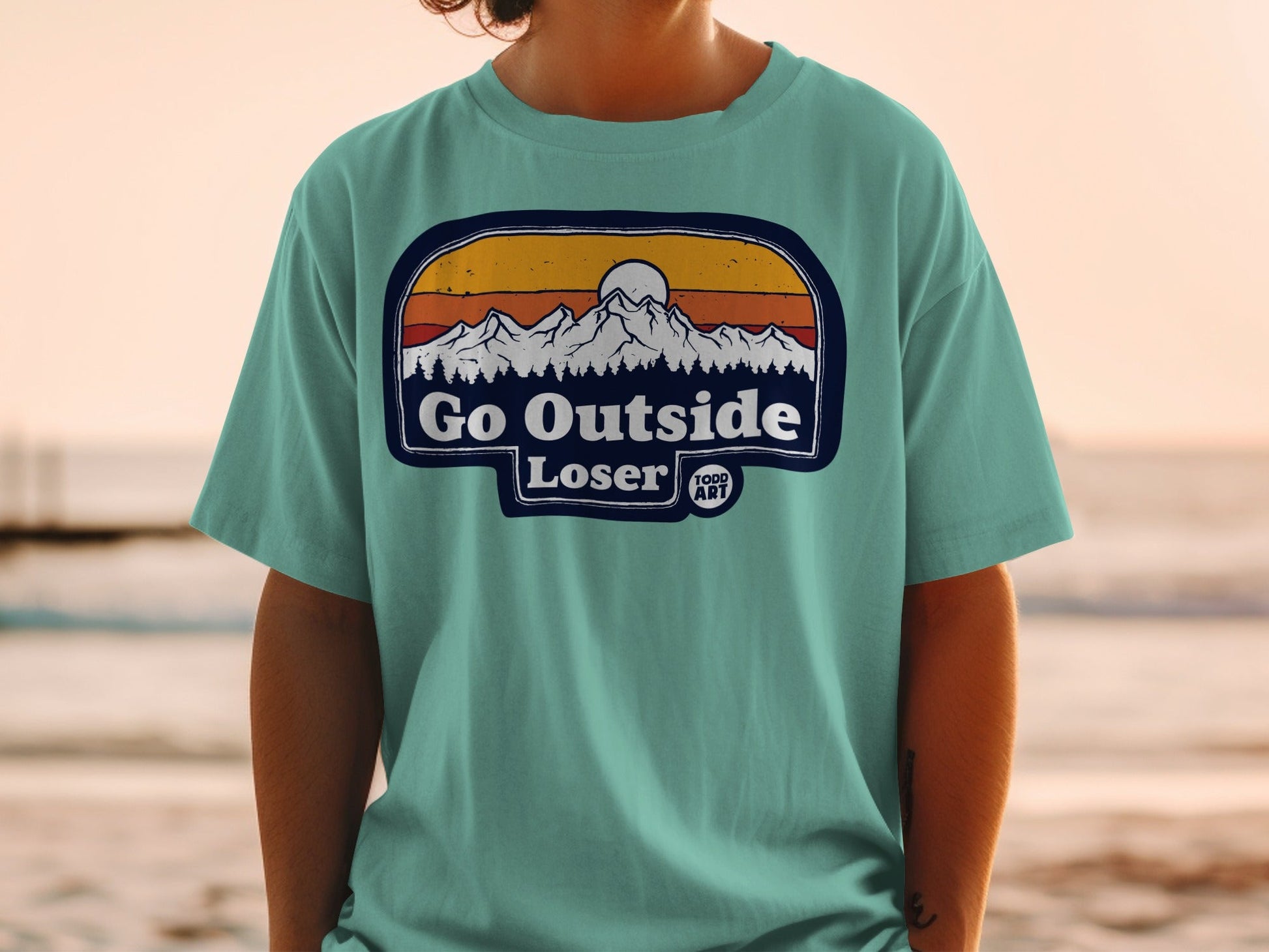 Teal t-shirt with "Go Outside Loser" mountain sunset graphic.