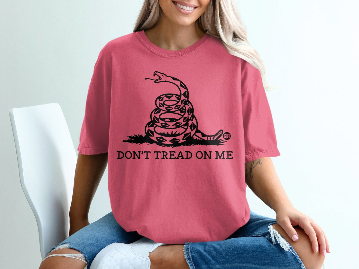 Pink t-shirt with coiled snake and "DON'T TREAD ON ME" text.