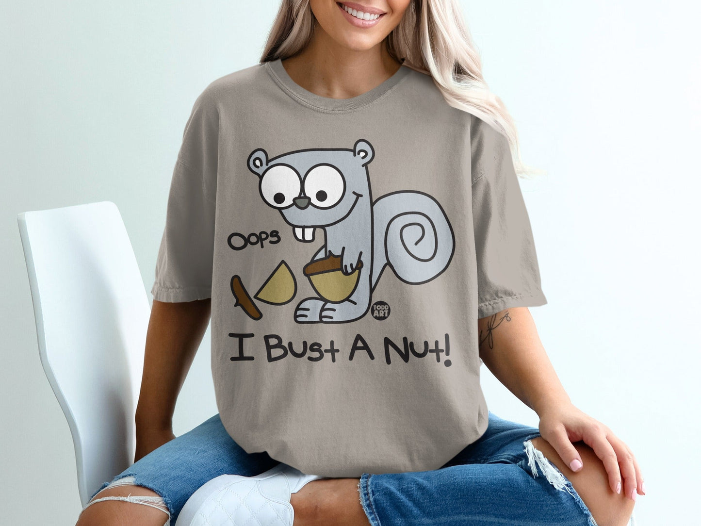 Cartoon squirrel with acorn shirt text "Oops I Bust a Nut!".