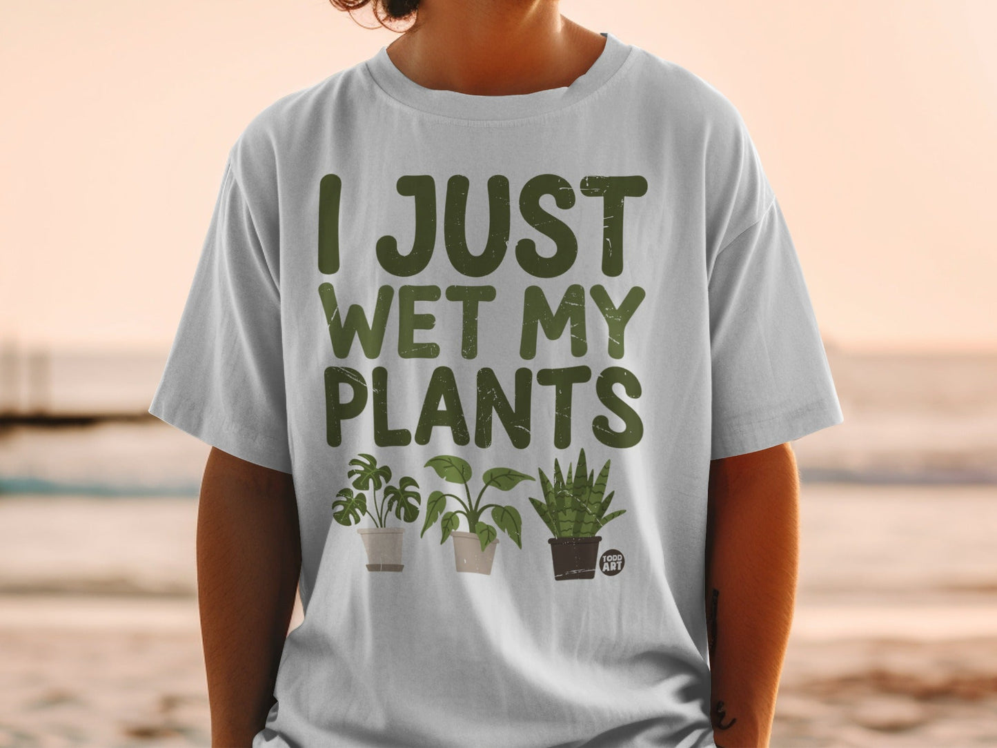 T-shirt with "I JUST WET MY PLANTS" text and three potted houseplants.