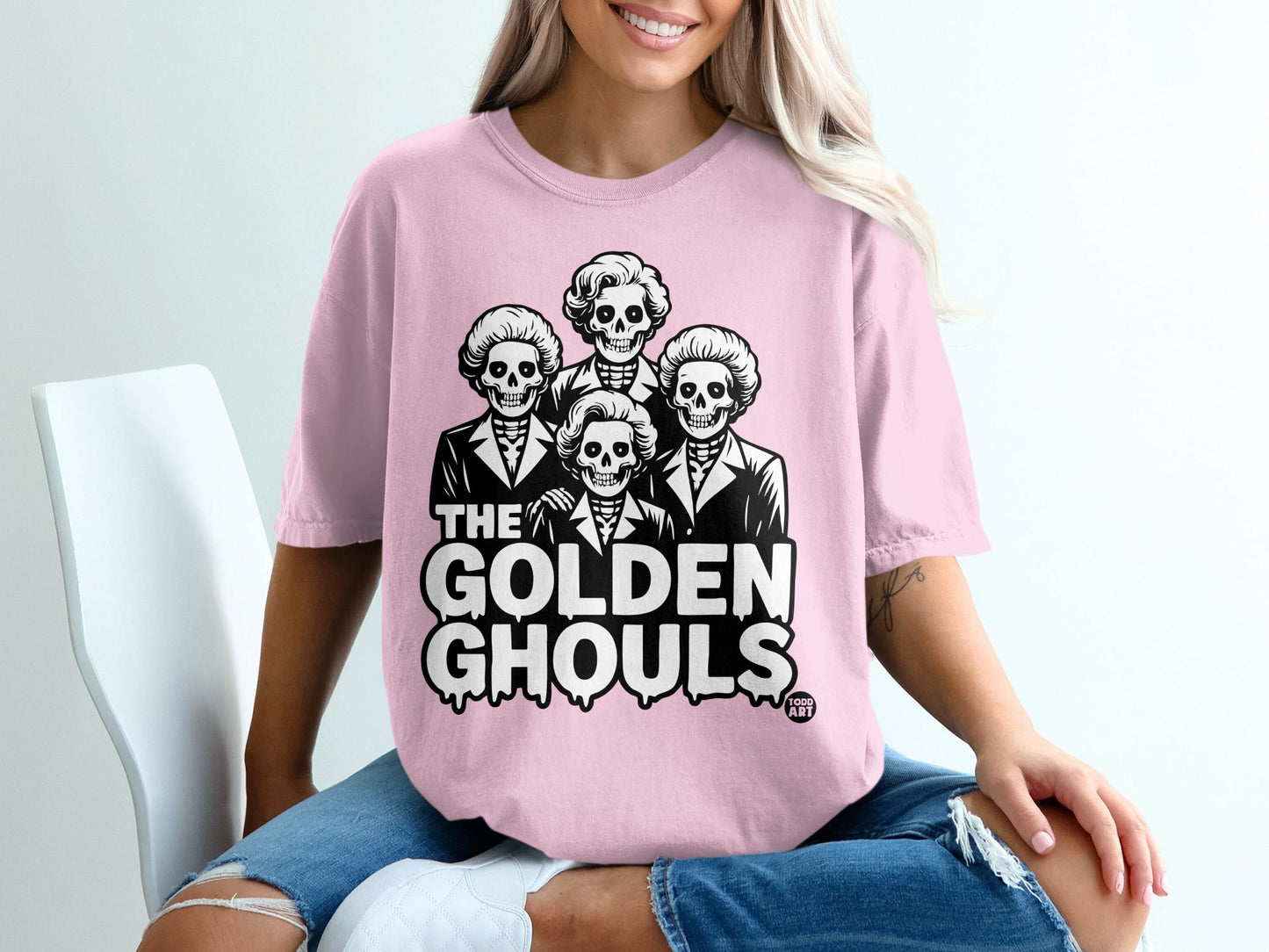 Pink t-shirt with "The Golden Ghouls" text and four skeleton heads.