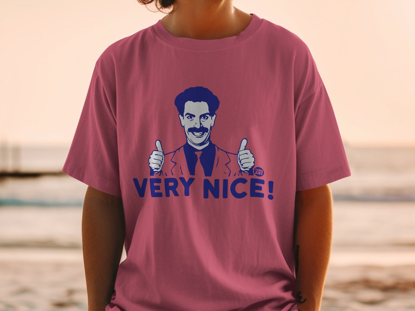 Borat giving two thumbs up with "VERY NICE!" text on a pink t-shirt.