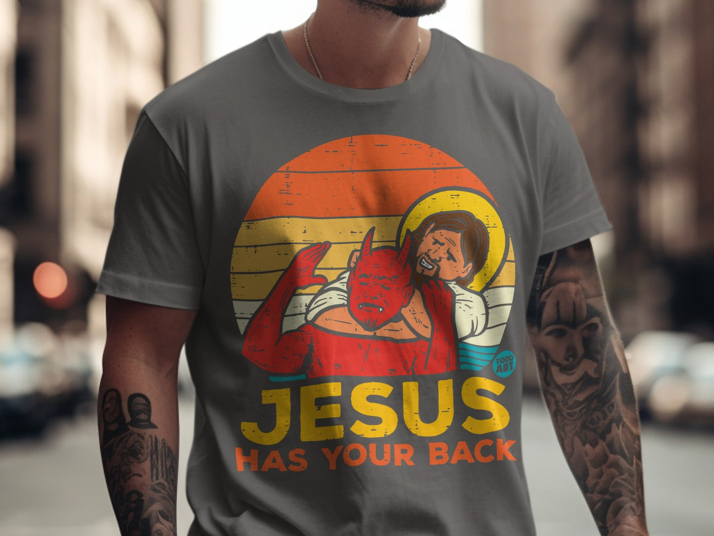 Retro sunset graphic of Jesus holding a devil, text "JESUS HAS YOUR BACK".