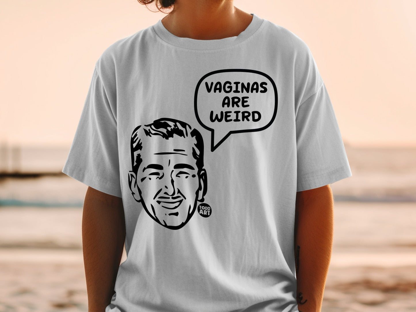 White t-shirt with cartoon man's face and speech bubble saying "VAGINAS ARE WEIRD".