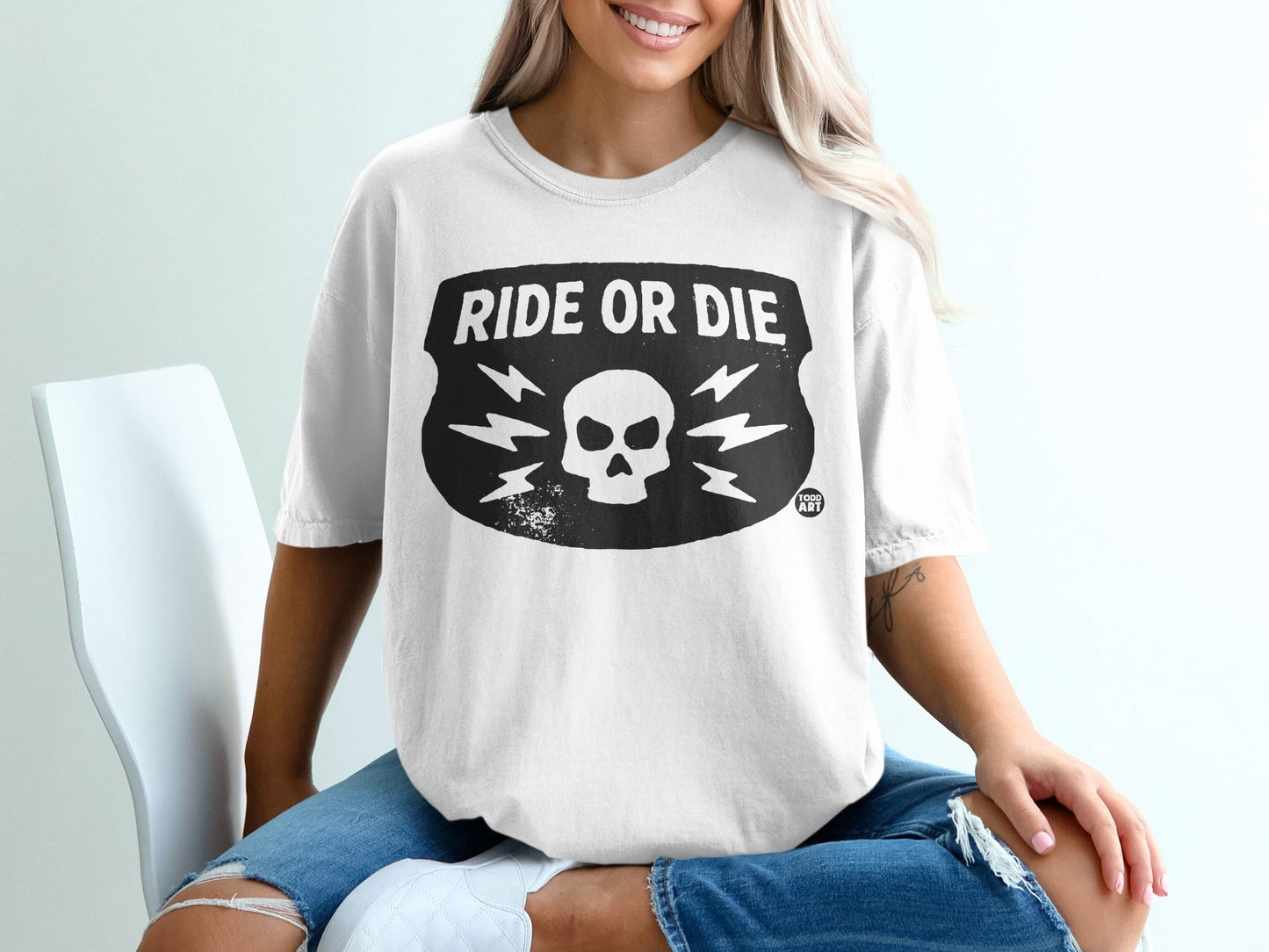 White t-shirt with "Ride or Die" skull and lightning bolt graphic.