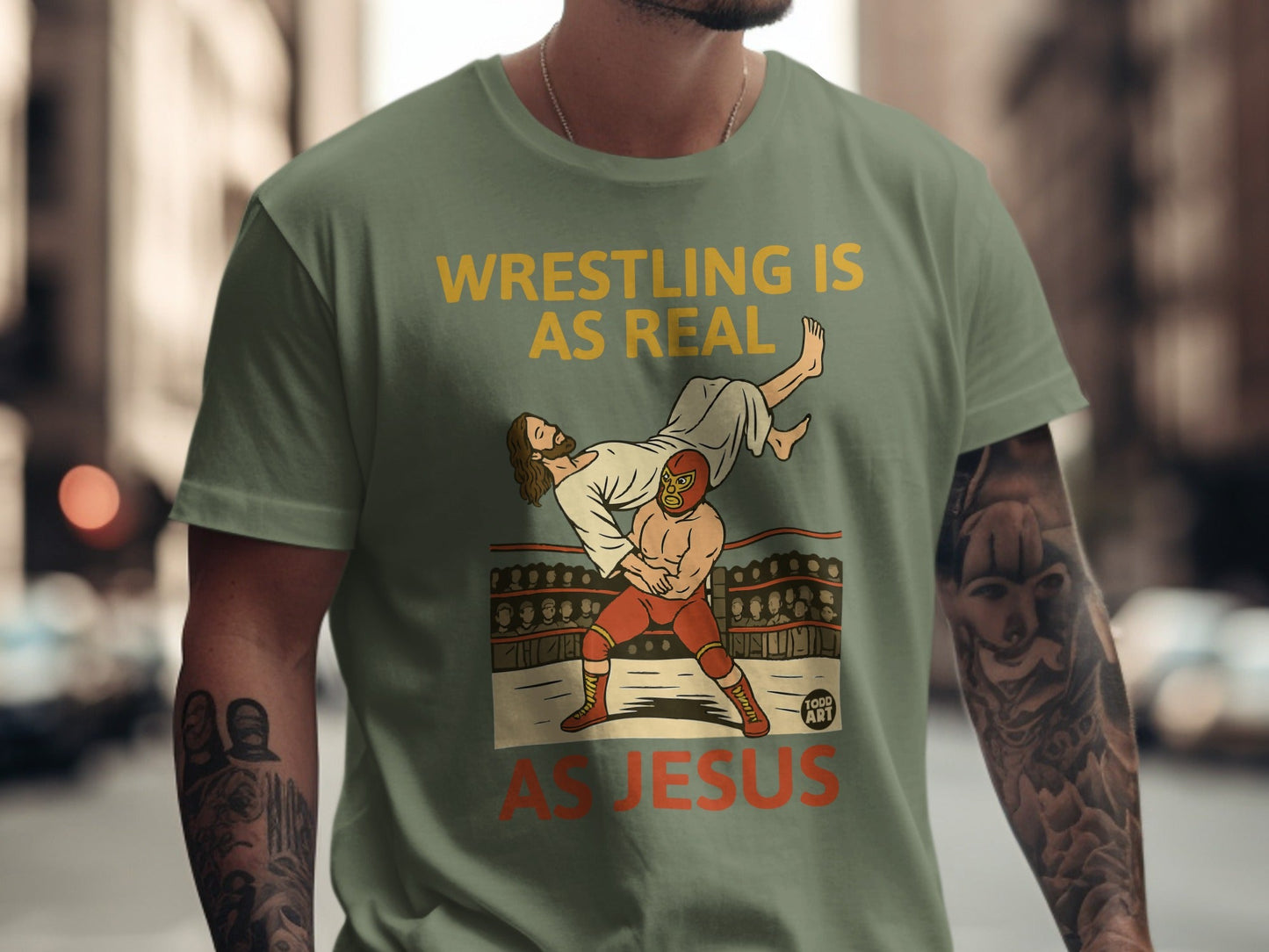 Green t-shirt with "Wrestling is real as Jesus" text and wrestling illustration.