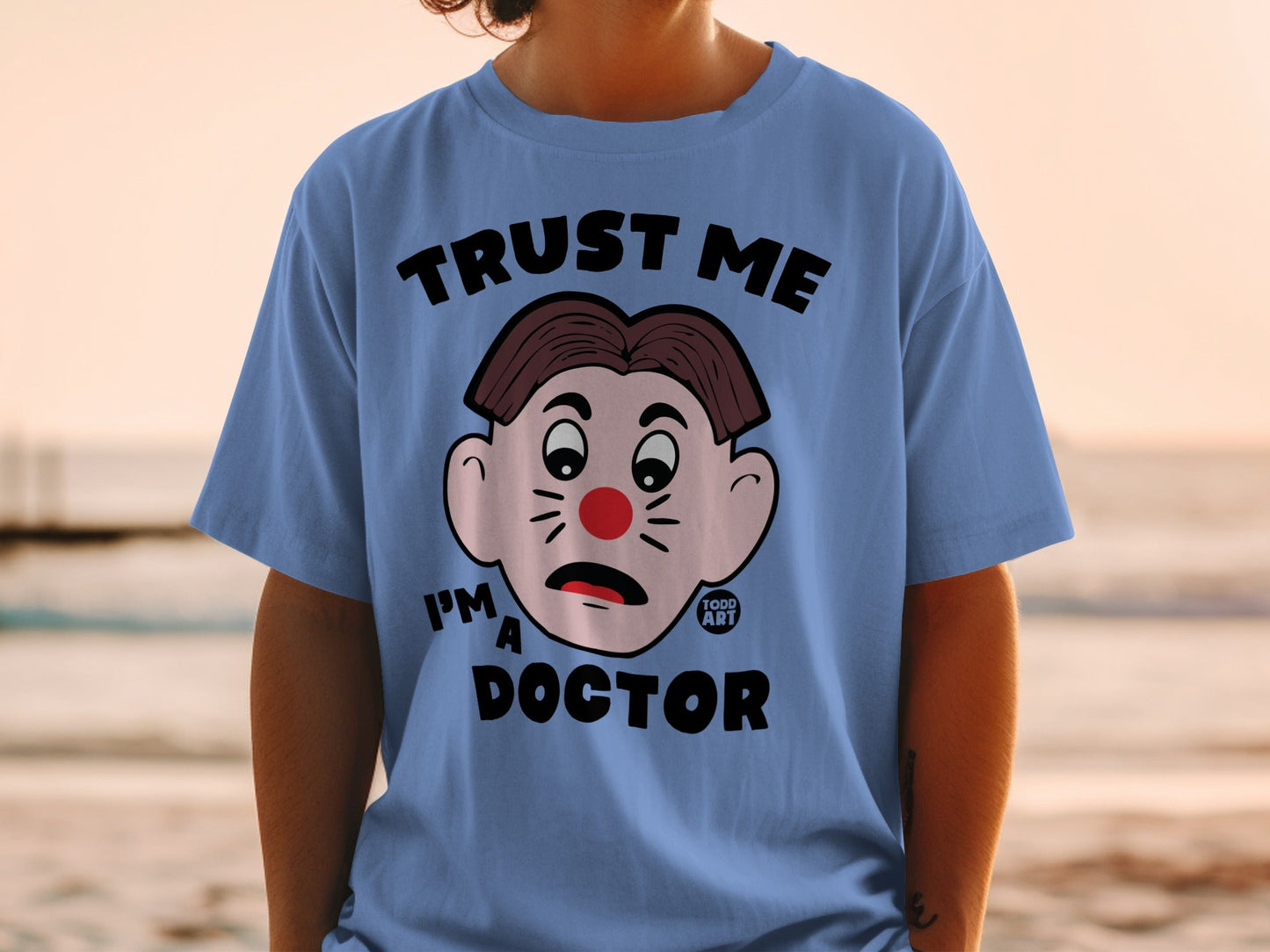 Blue t-shirt with "Trust Me I'm a Doctor" and cartoon face.