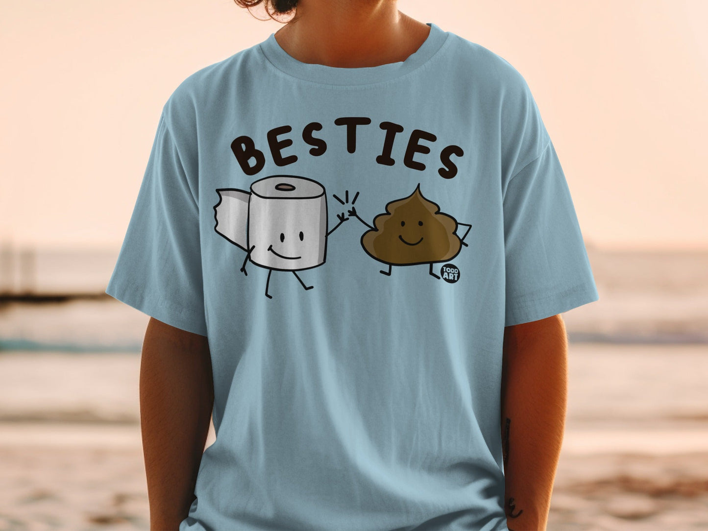 Light blue t-shirt with cartoon toilet paper and poop characters saying "BESTIES".
