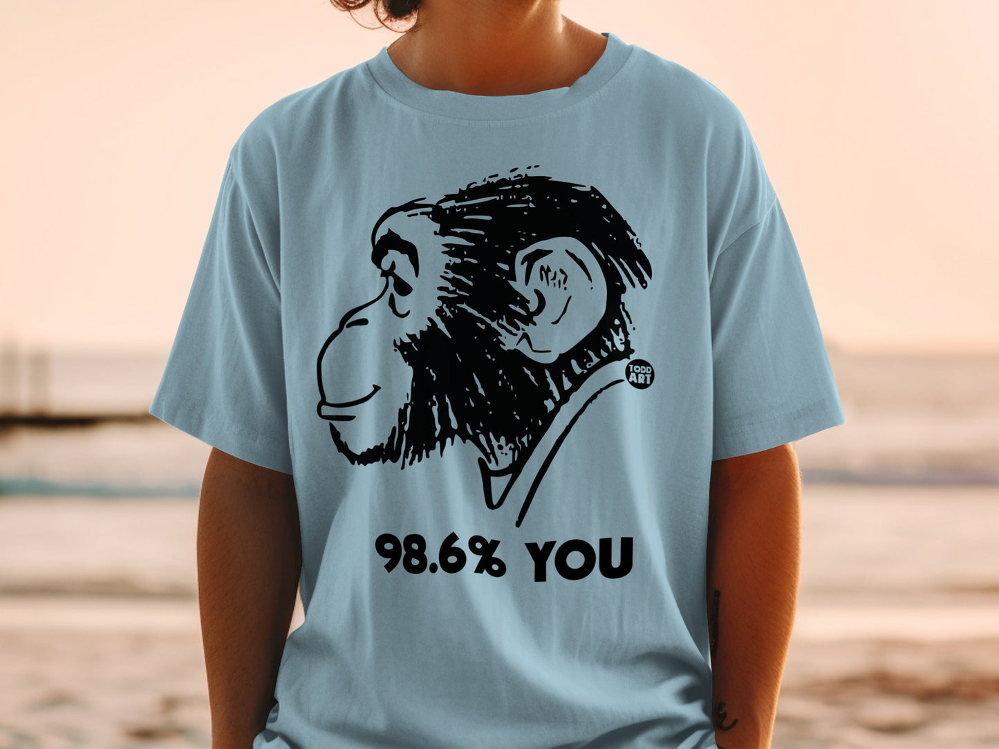 Light blue t-shirt with a black line drawing of a monkey's head and "98.6% YOU".