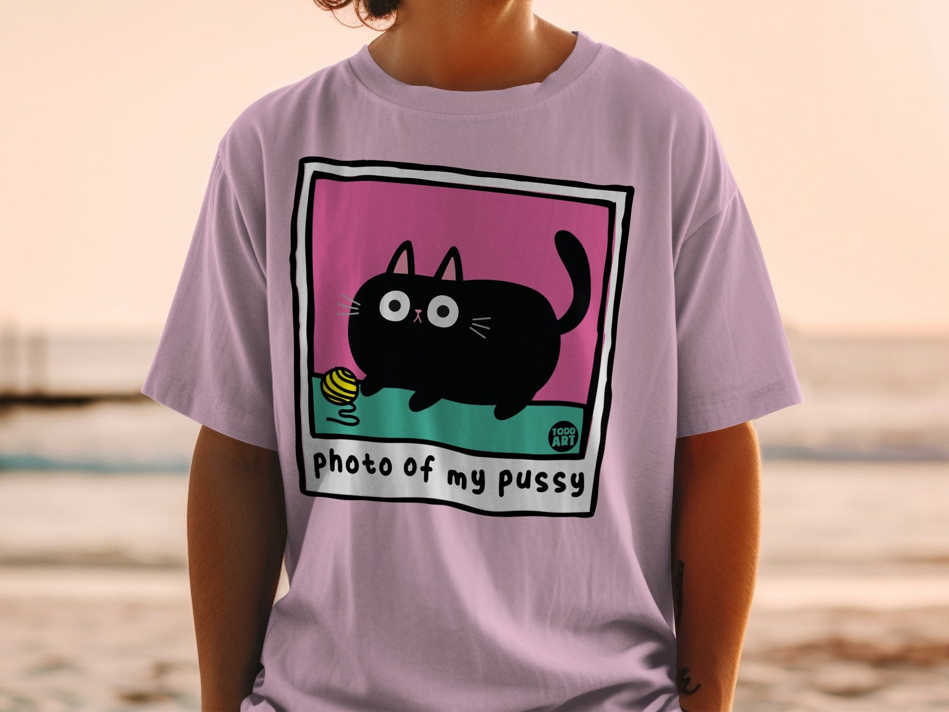 Black cartoon cat with yarn ball on a pink t-shirt.