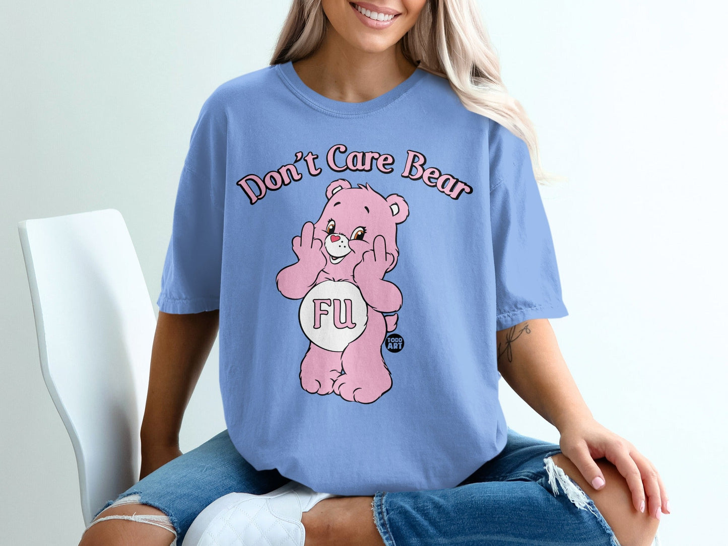 Pink cartoon bear wearing shirt with "FU" and "Don't Care Bear" text.