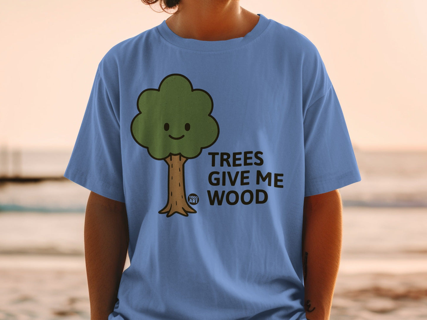 Blue t-shirt with a smiling cartoon tree graphic and text "TREES GIVE ME WOOD".