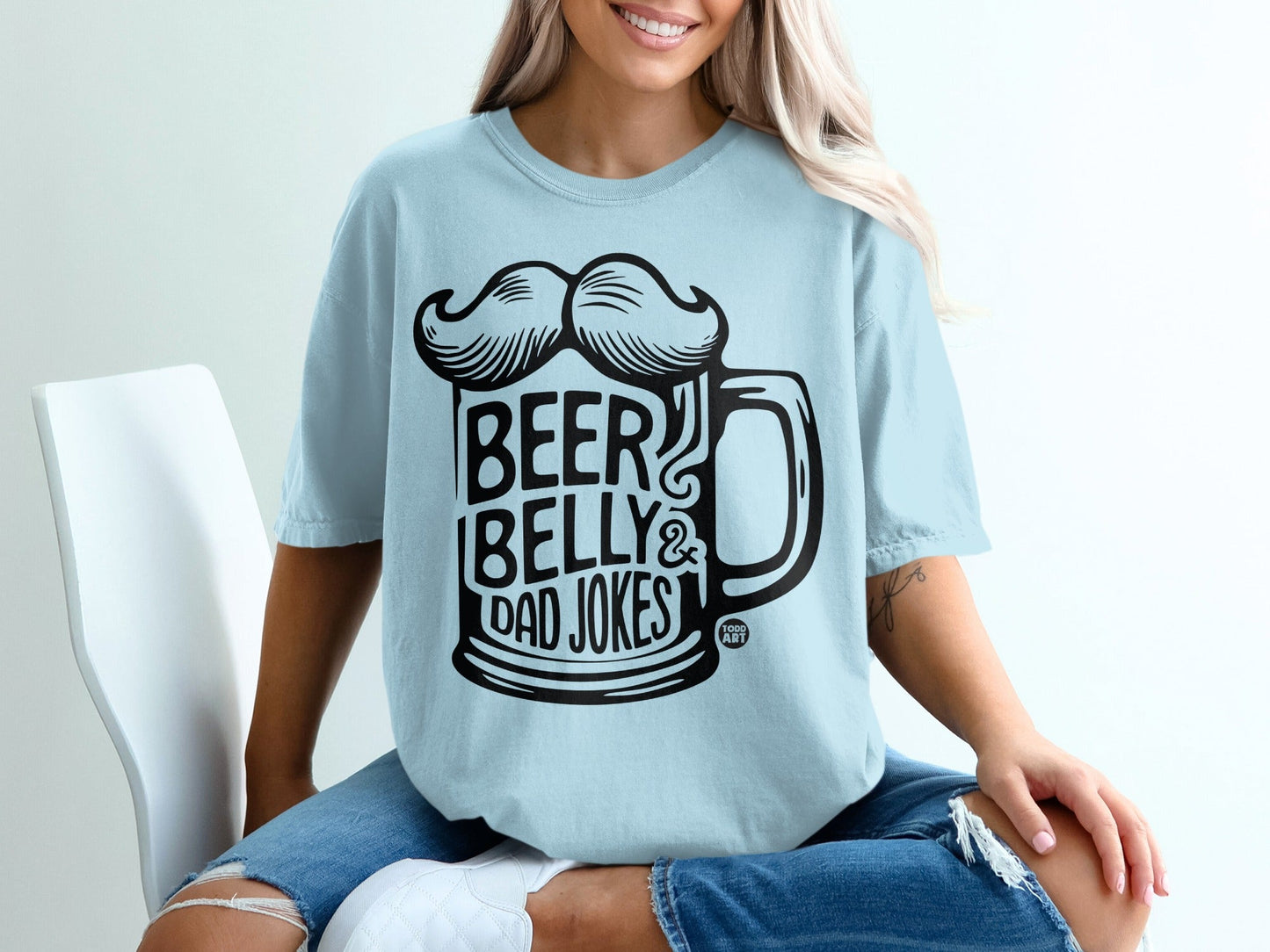 Light blue t-shirt with black text and mustache graphic: "Beer Belly & Dad Jokes".