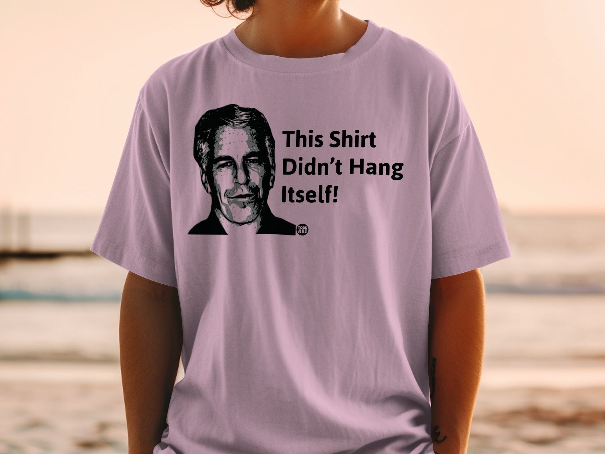 T-shirt with drawing of Jeffrey Epstein and text "This Shirt Didn't Hang Itself!"