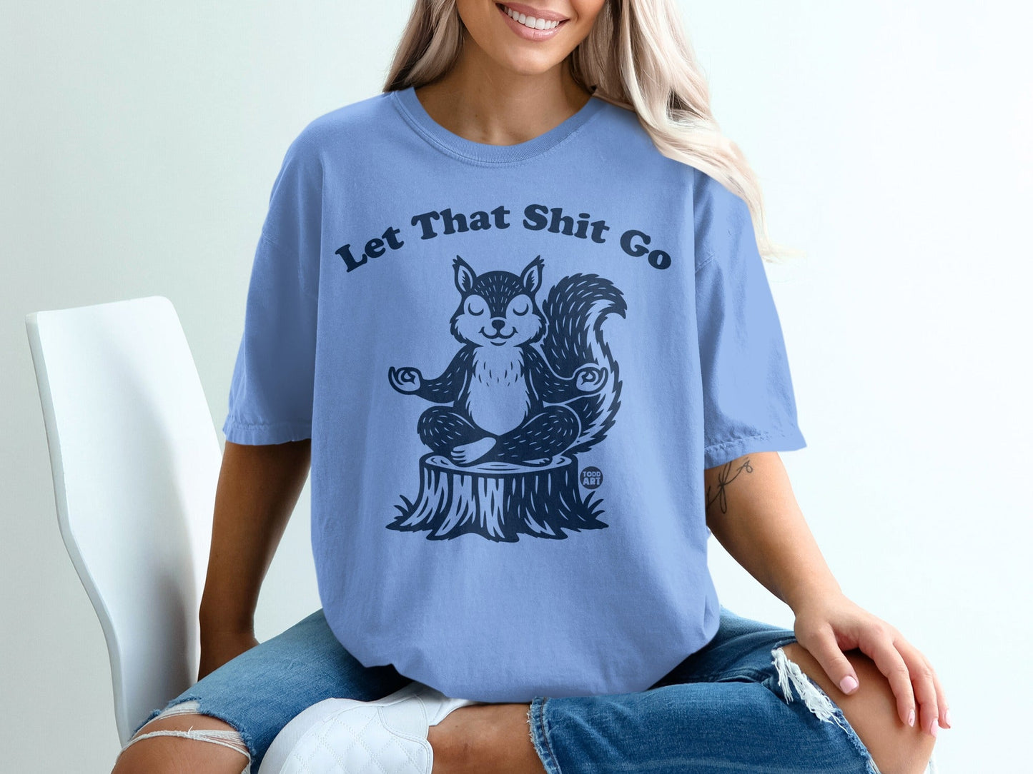 Light blue t-shirt with a meditating squirrel and "Let That Sh*t Go" text.