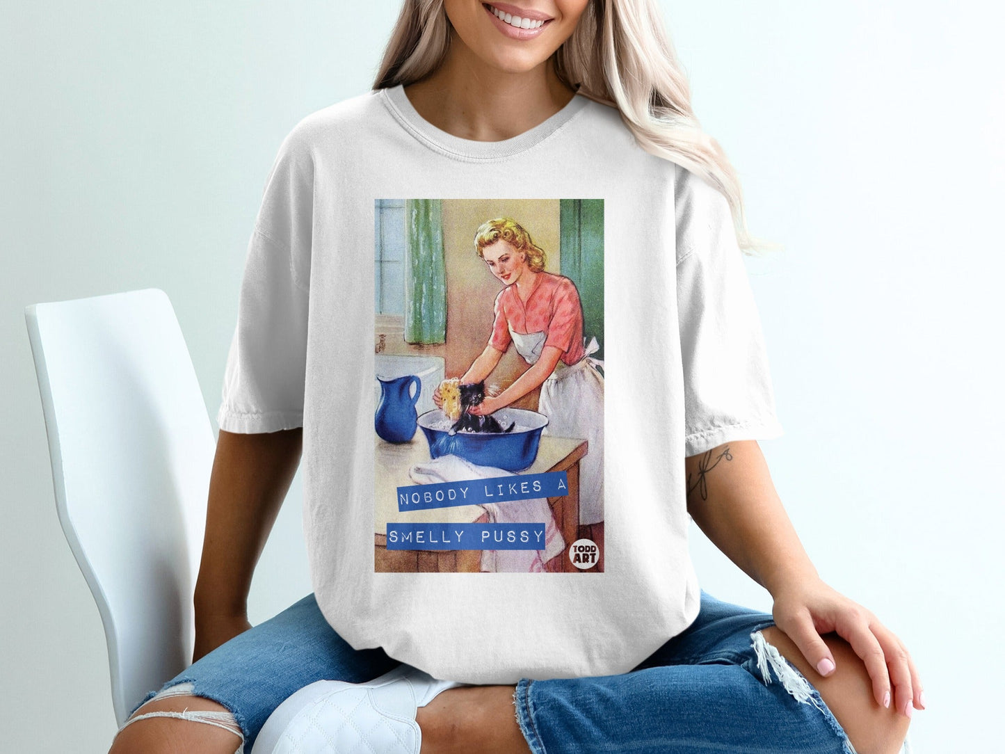 Woman washes a cat in a sink with text "NOBODY LIKES A SMELLY PUSSY".