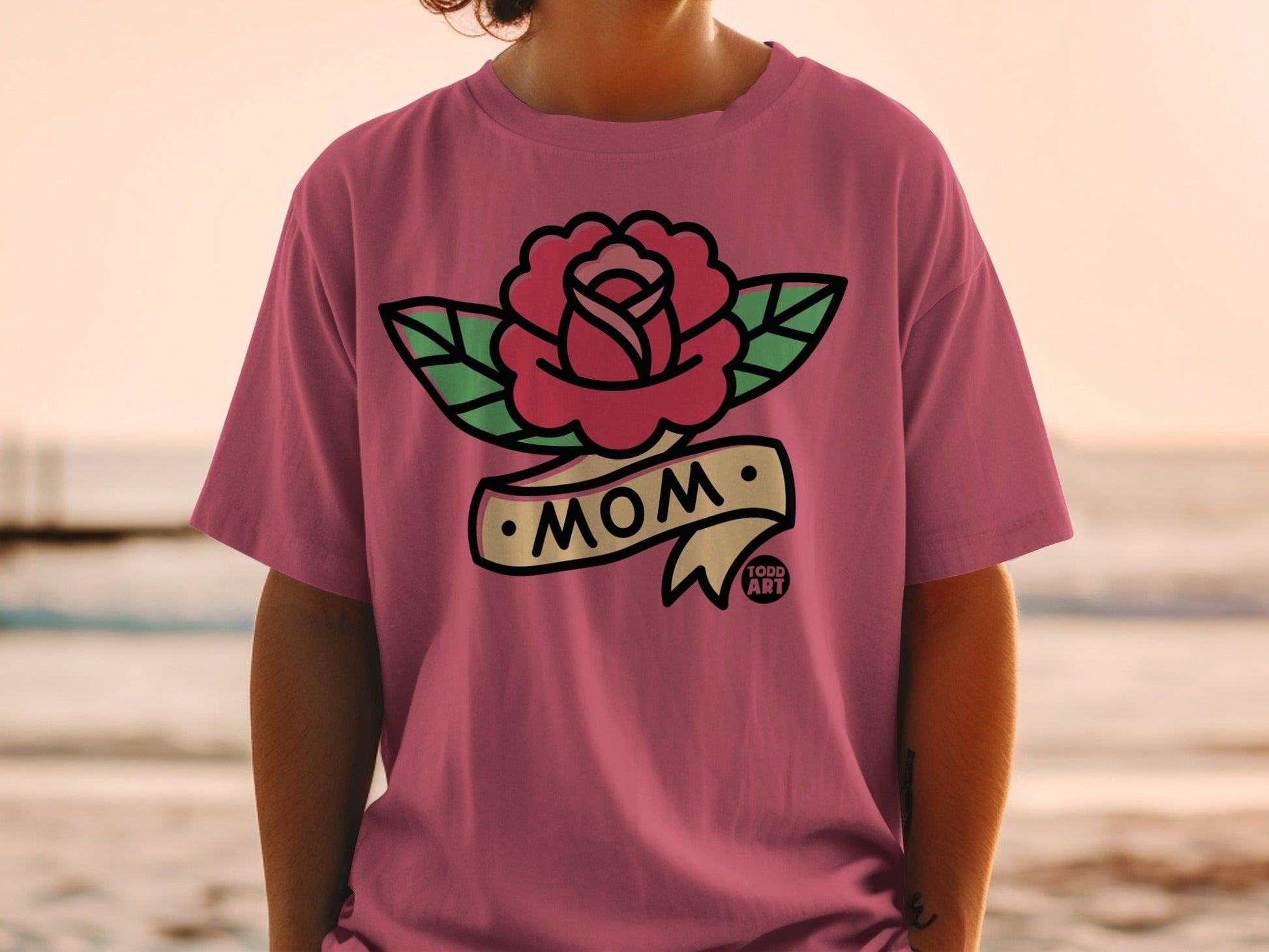Pink t-shirt with rose and ribbon tattoo design that says "Mom".