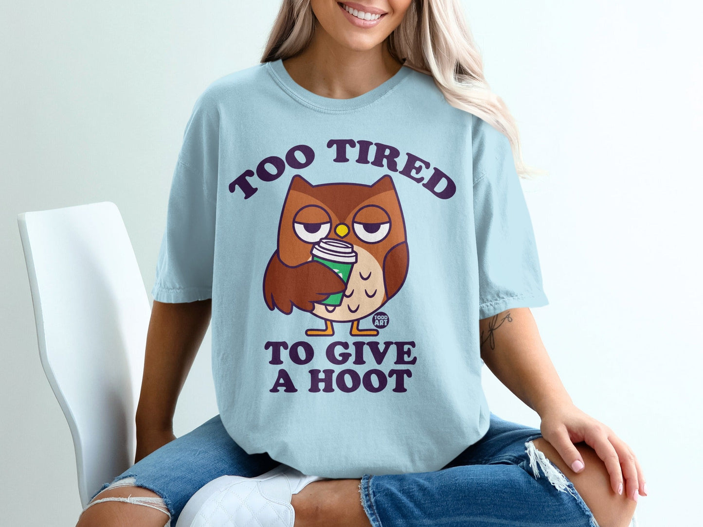 Light blue t-shirt with cartoon owl drinking coffee, text "TOO TIRED TO GIVE A HOOT".