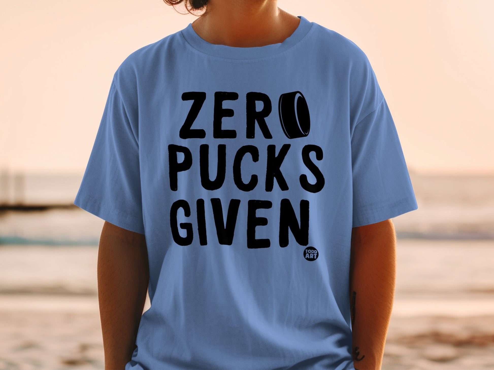 Blue t-shirt with "ZERO PUCKS GIVEN" text and a hockey puck.