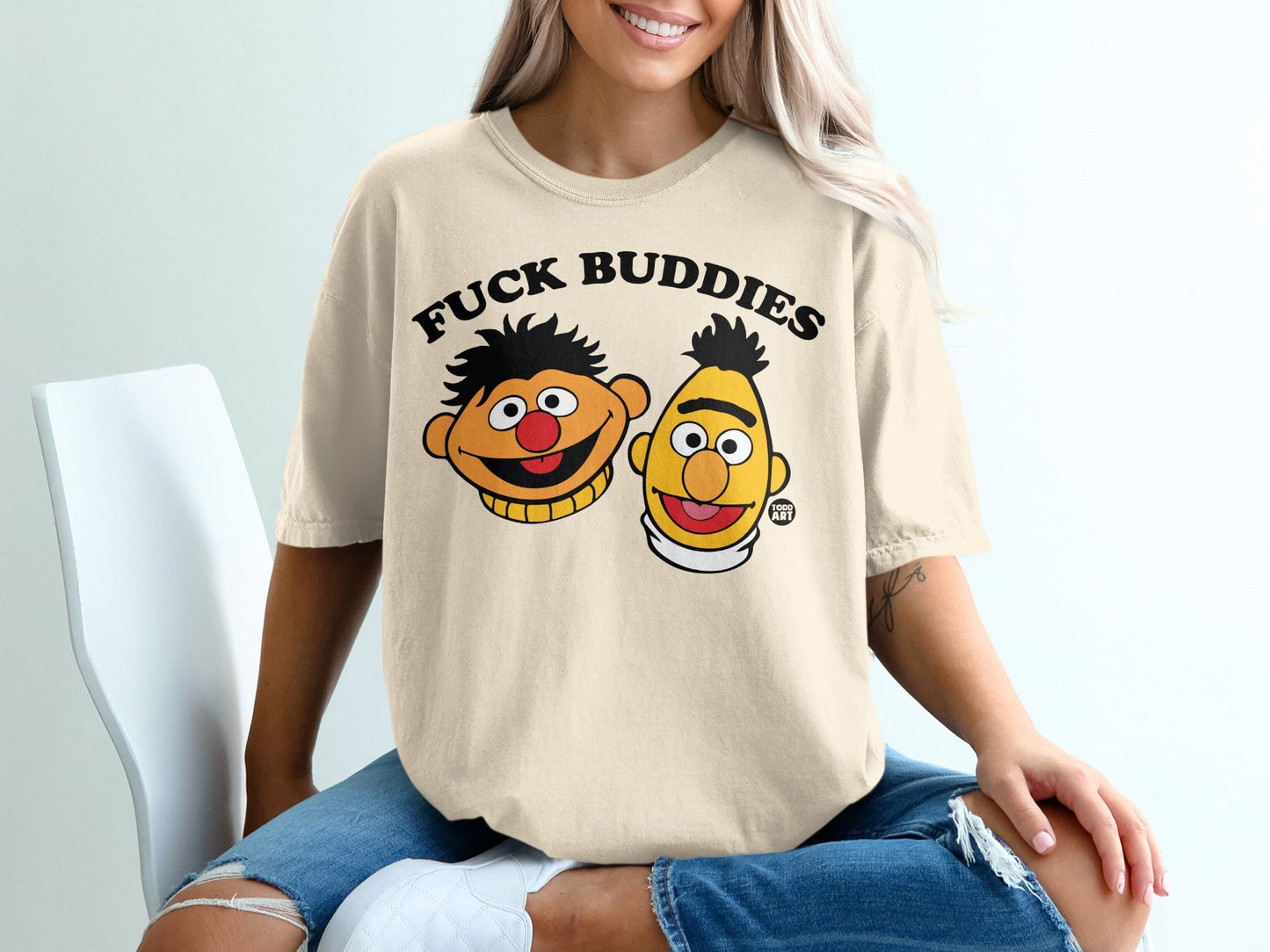 Cream t-shirt with cartoon characters and "FUCK BUDDIES" text.