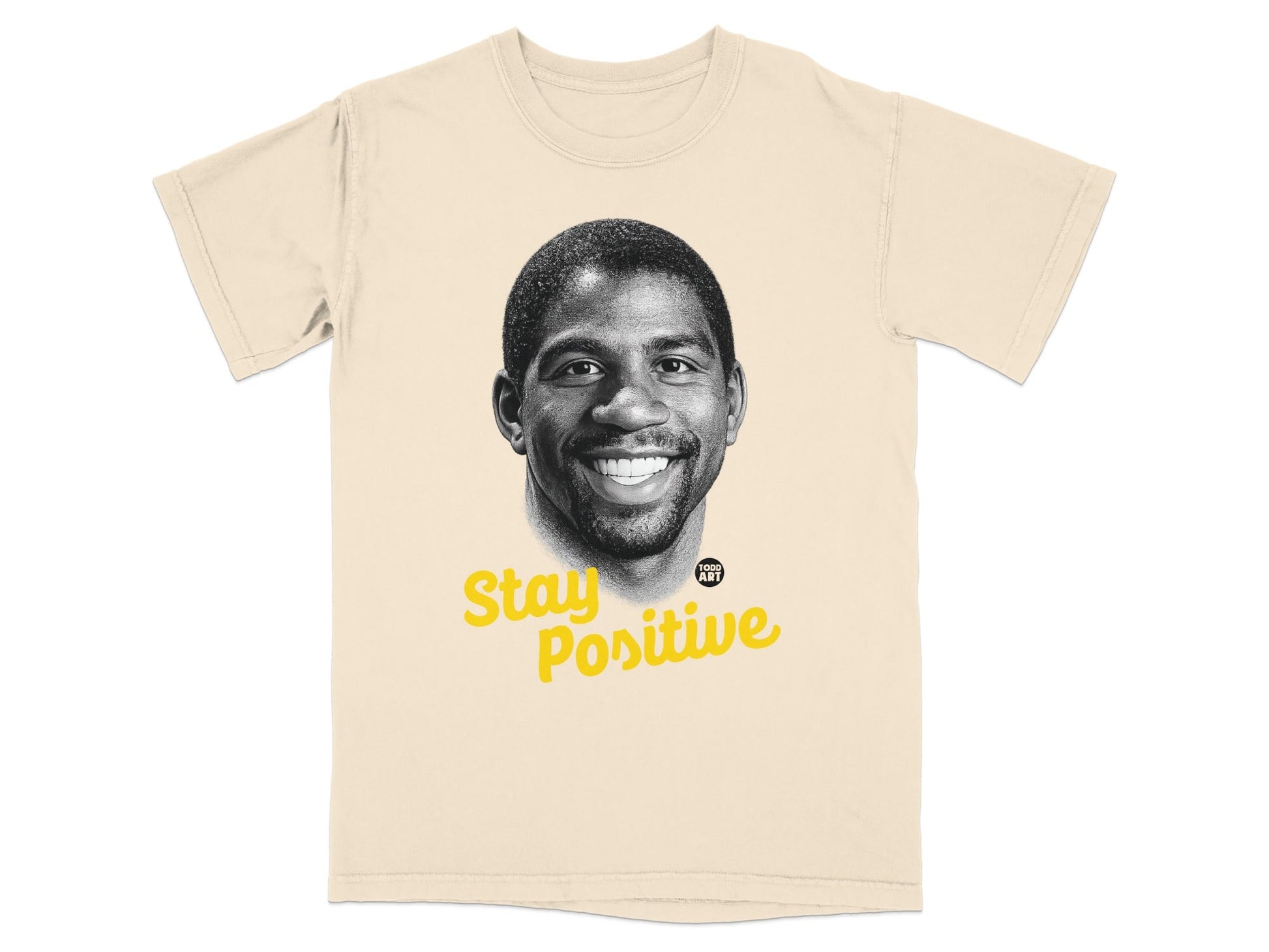 Magic Johnson portrait with "Stay Positive" text on a light tan t-shirt.