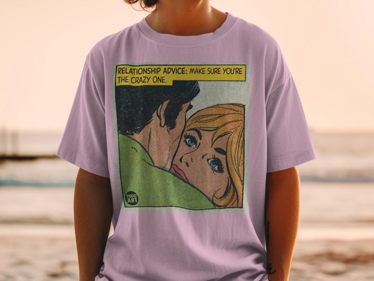Lilac t-shirt with a comic panel showing a couple, "RELATIONSHIP ADVICE: MAKE SURE YOU'RE THE CRAZY ONE."