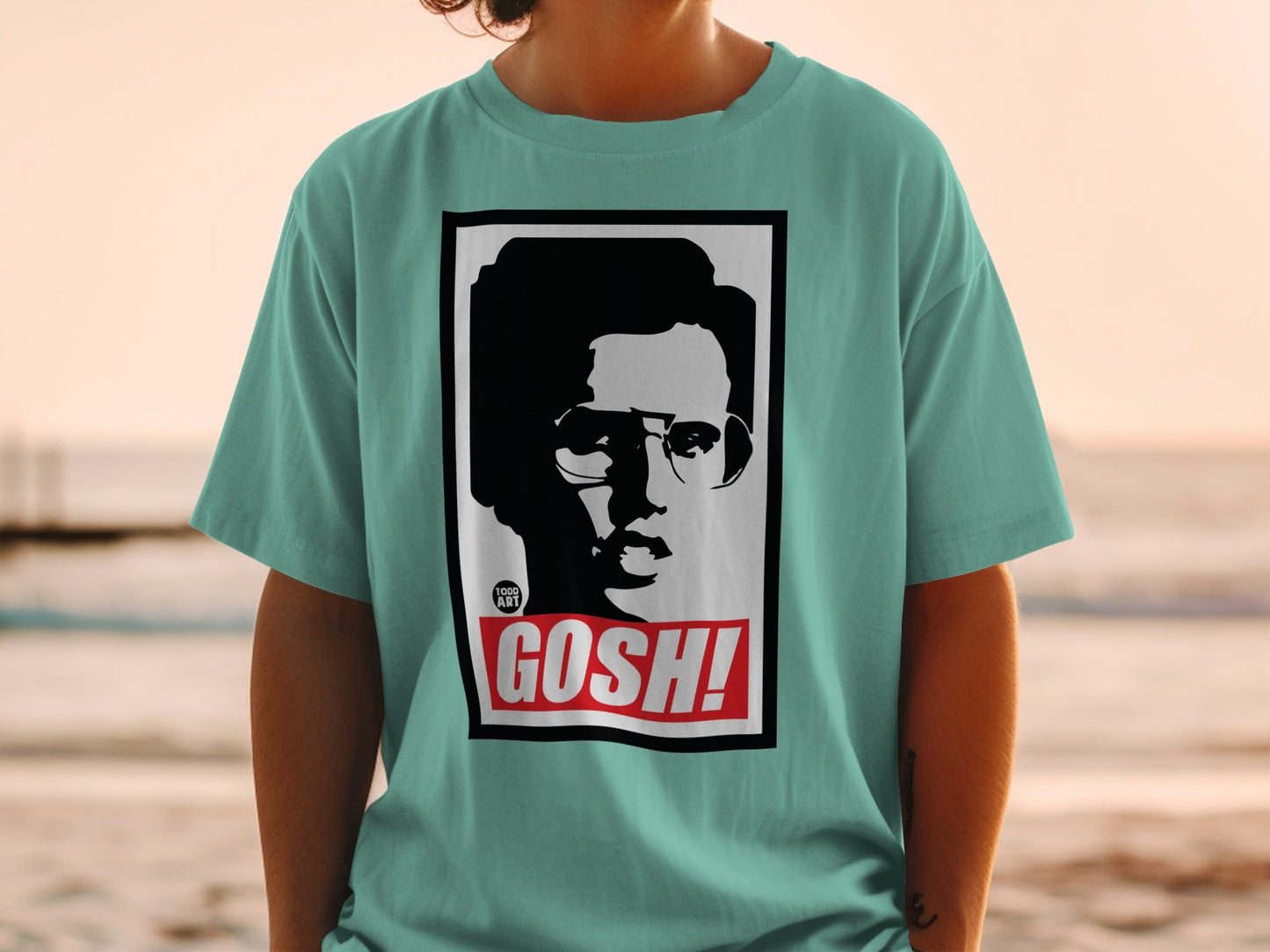 Teal t-shirt with a black and white graphic of a person's face and "GOSH!" text.